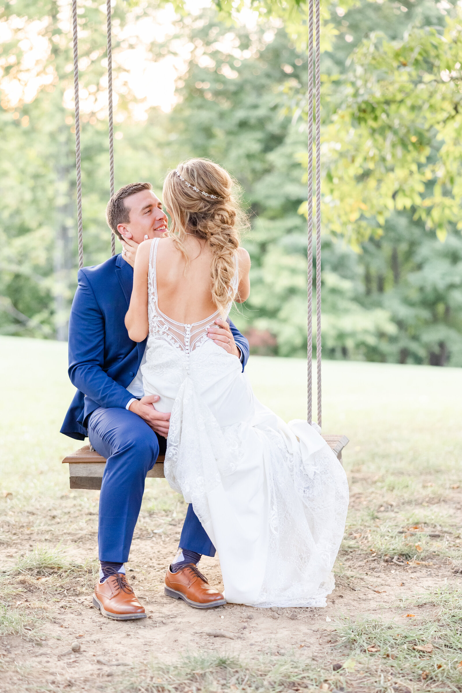 bright light and airy wedding photo of bride  and groom on romantic tree swing