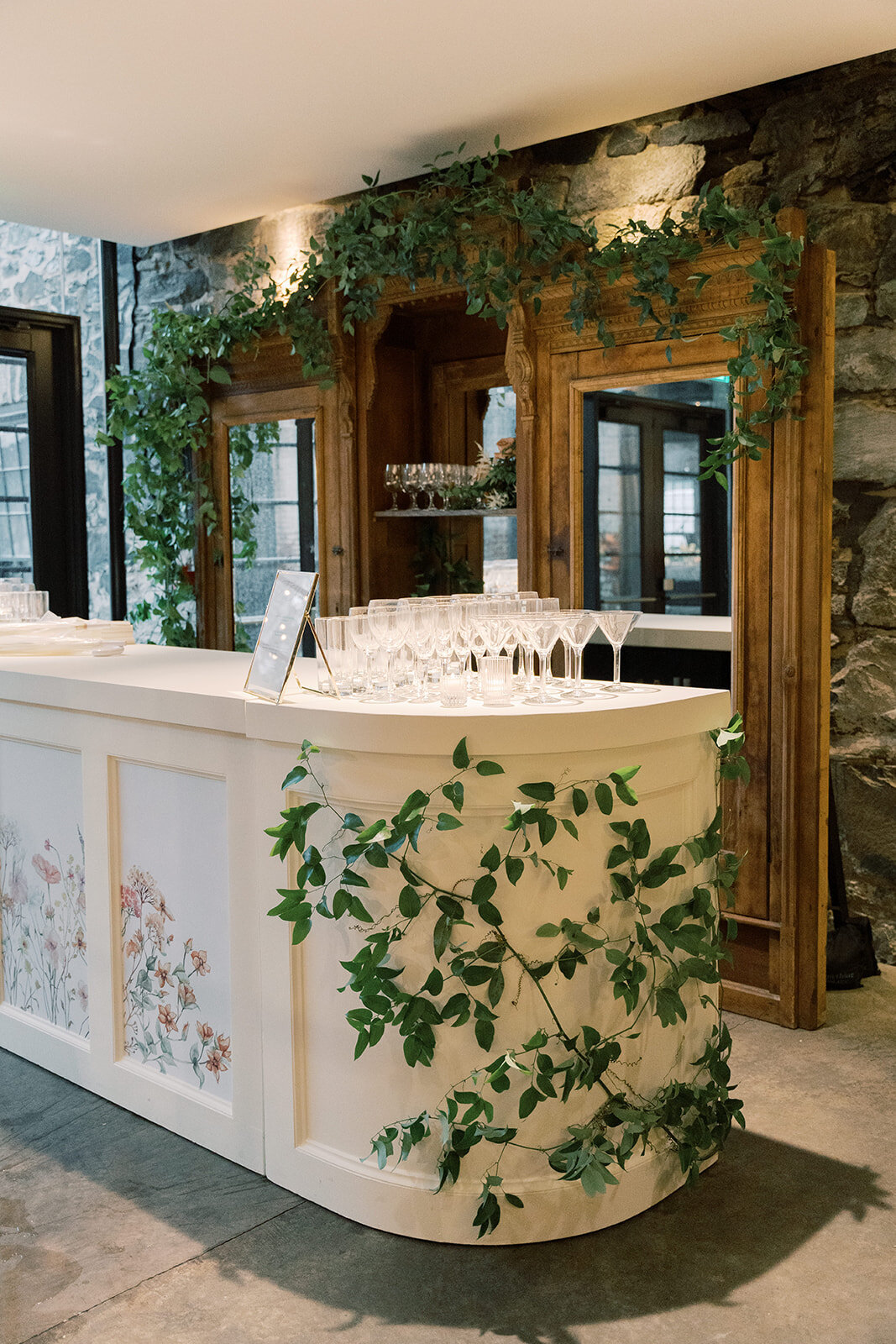Large white bar inside Washington mill dye house with smilax greenery vining around it.