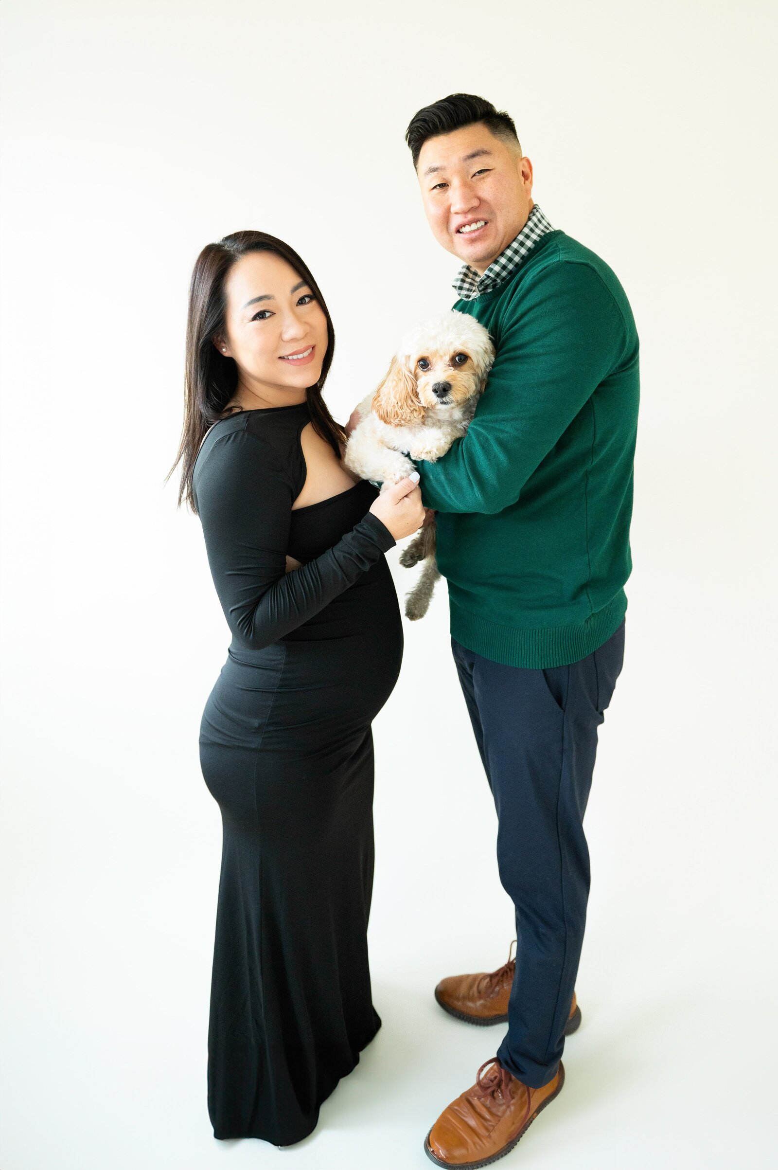 couple holding their dog during a pregnancy photoshoot