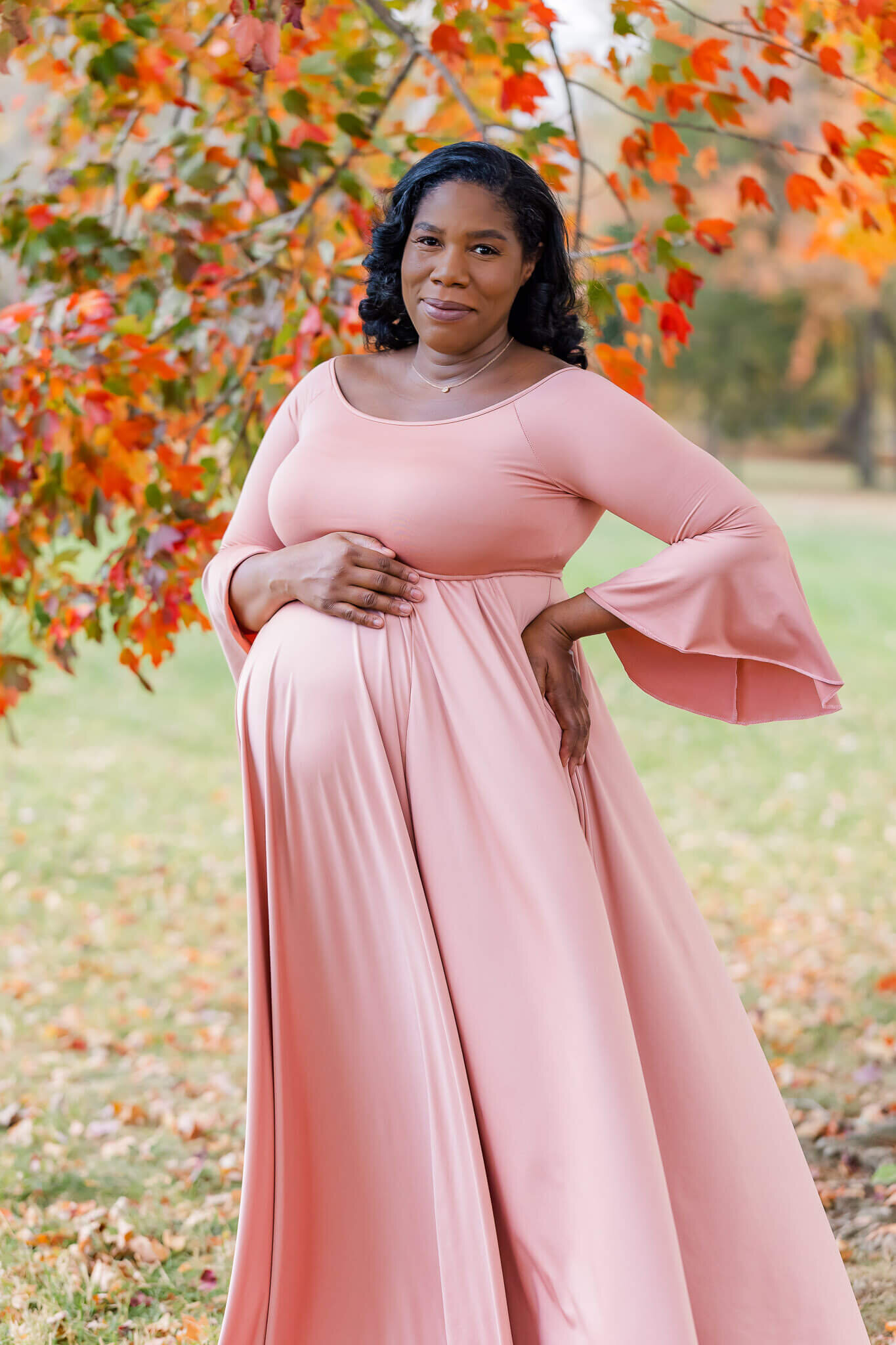A mother-to-be embracing her pregnant belly during her maternity session in Alexandria, VA.
