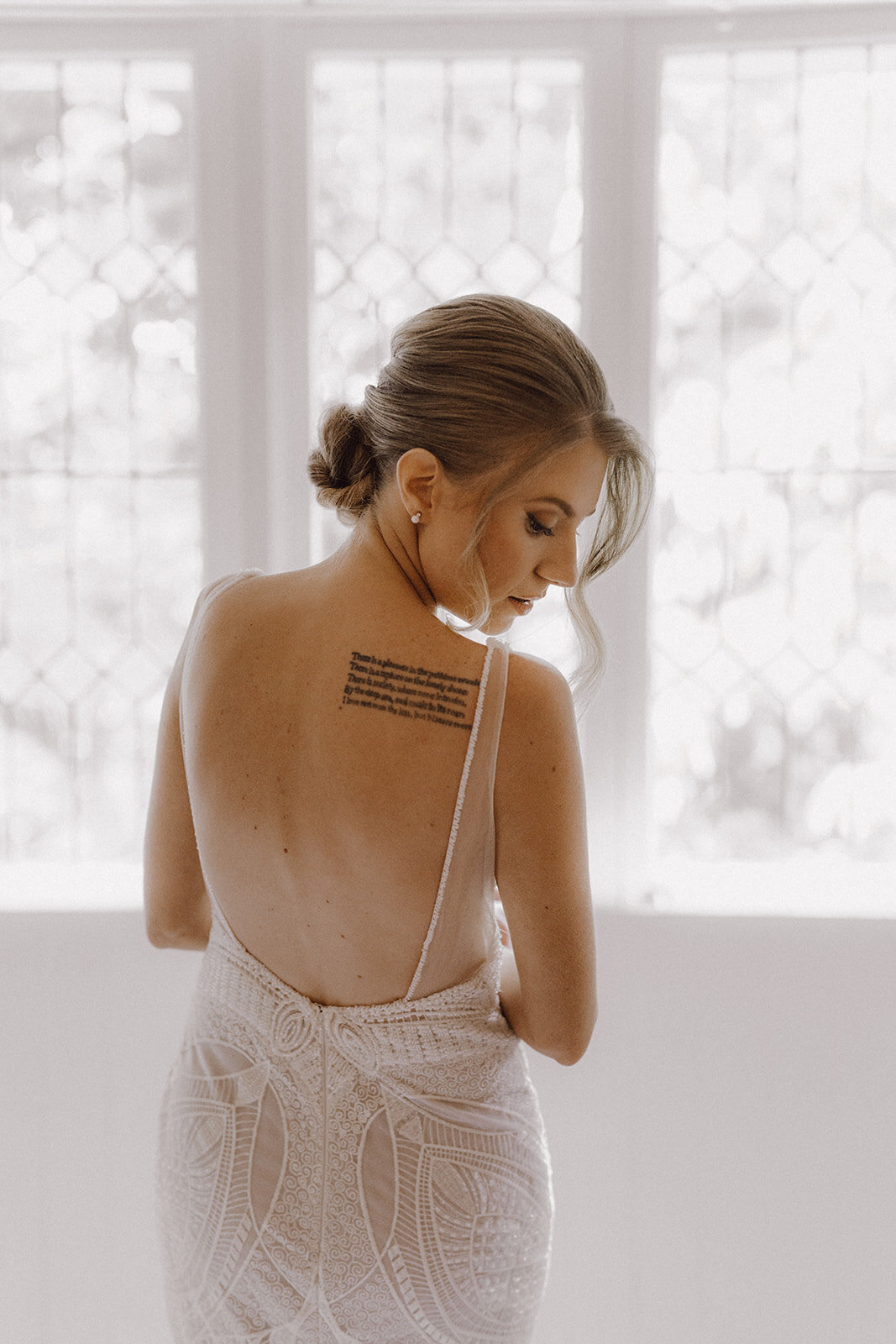 Bella Rae Bride Heather looking back with a beautiful twisted low bun and soft glam makeup captured by Daniel Chafer Photography at Tiffanys Maleny