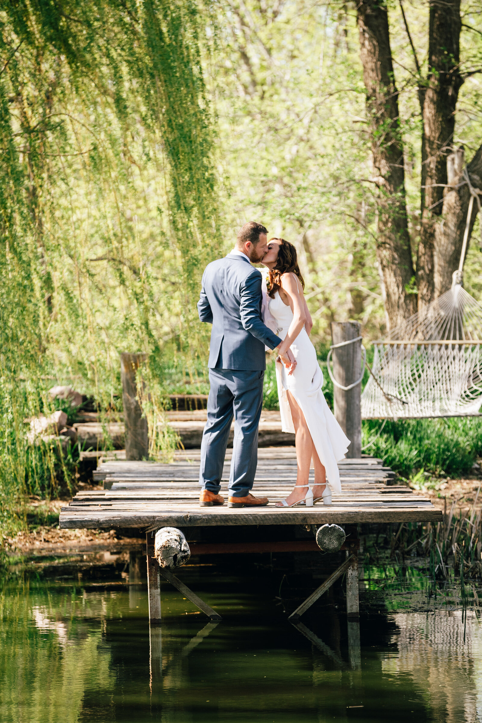 Bride and groom by pond in Nebraska