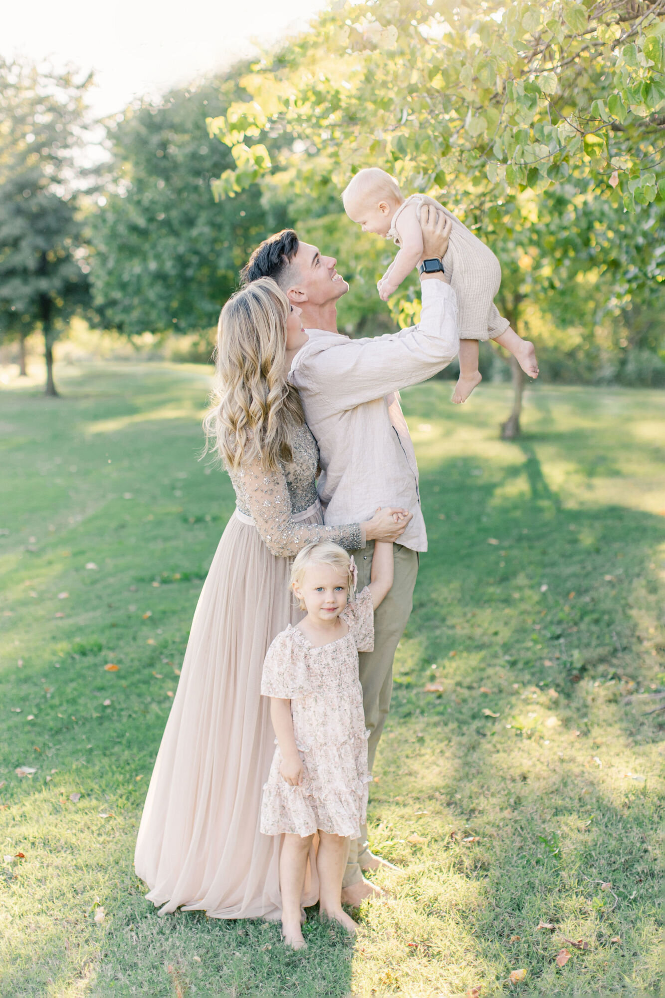 Dad throwing baby in the air during outdoor photo shoot.