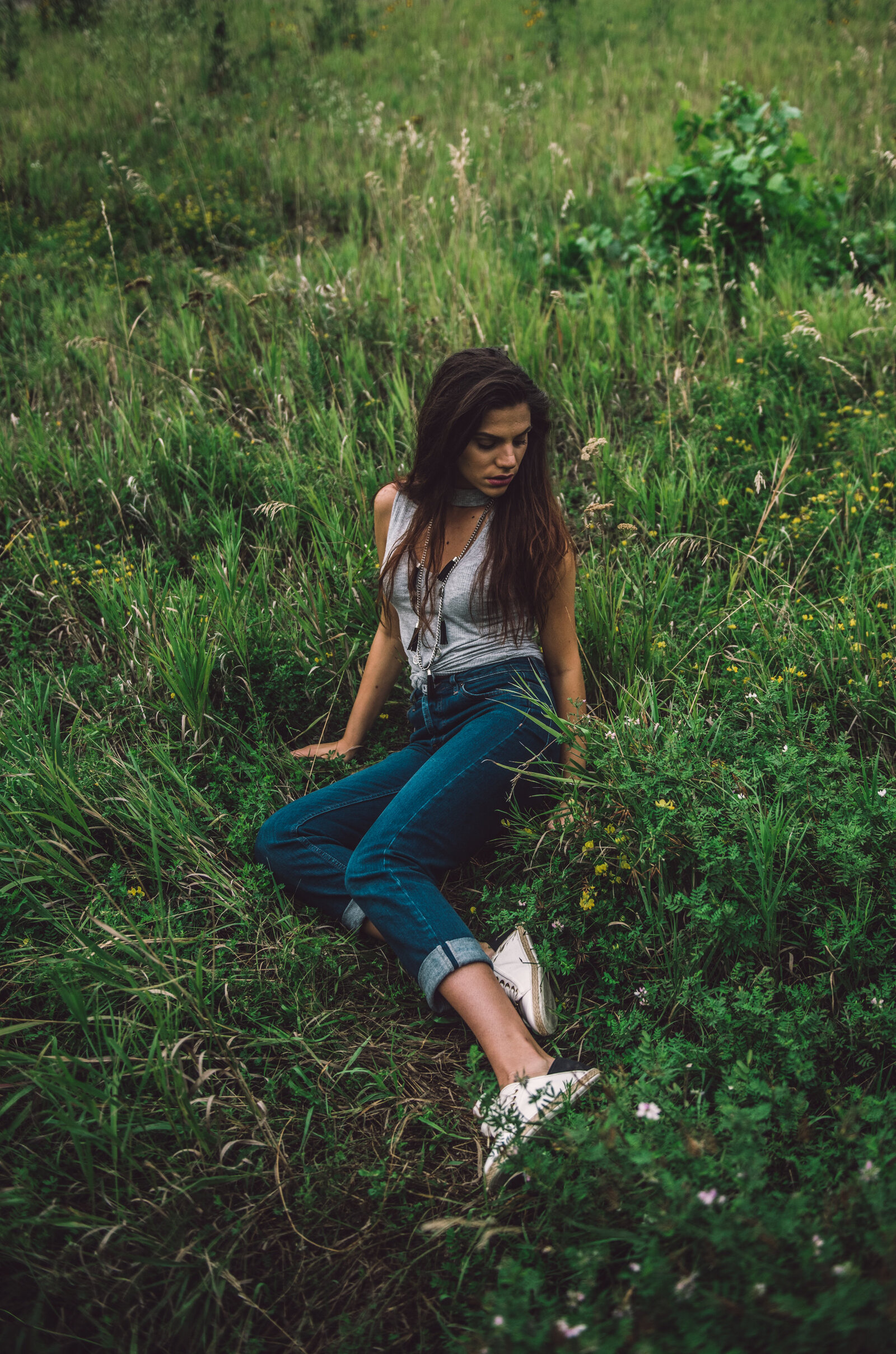 Gril n jeans sitting in grass