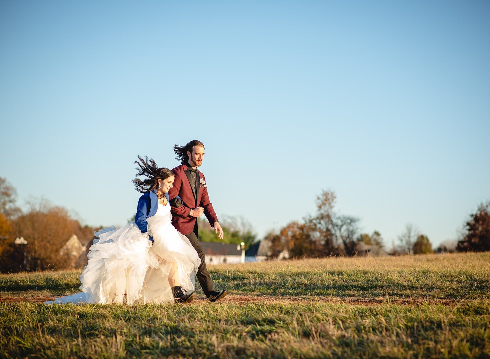 elopement couple skipping through field
