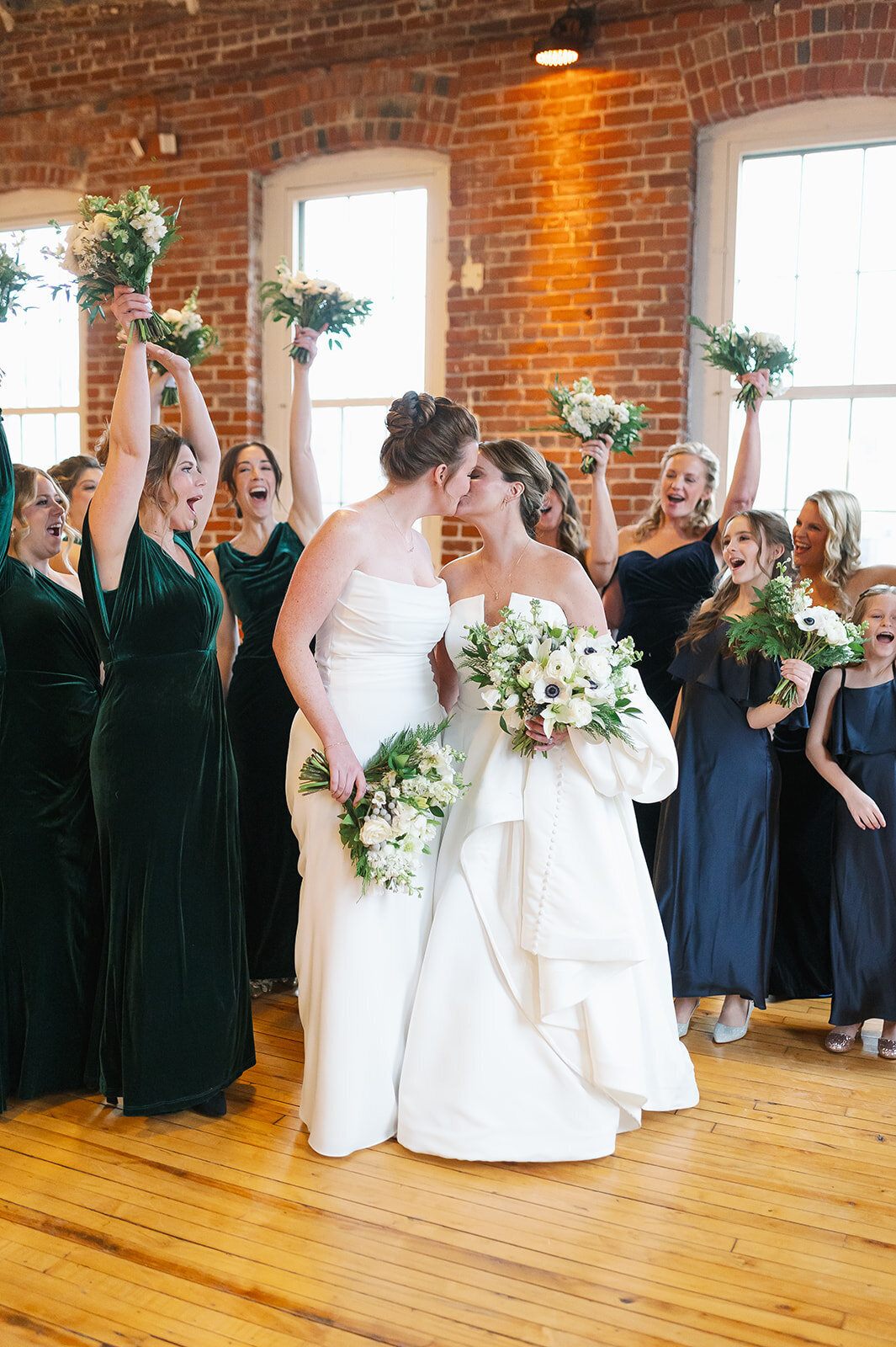 brides-kissing-wedding-party-cheering