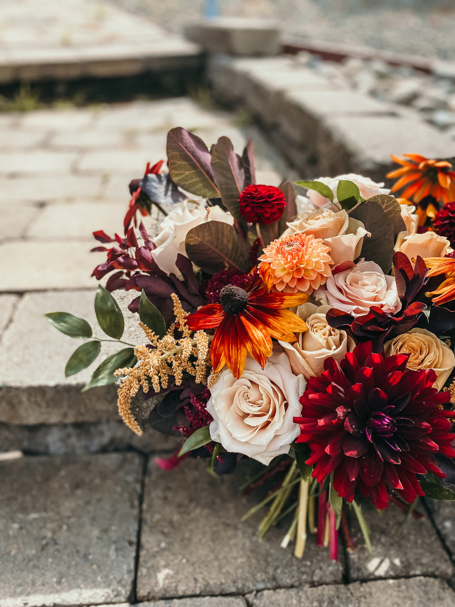 This bridal bouquet holds vivid colors with dahlias, rudbeckia, smoke bush and roses.