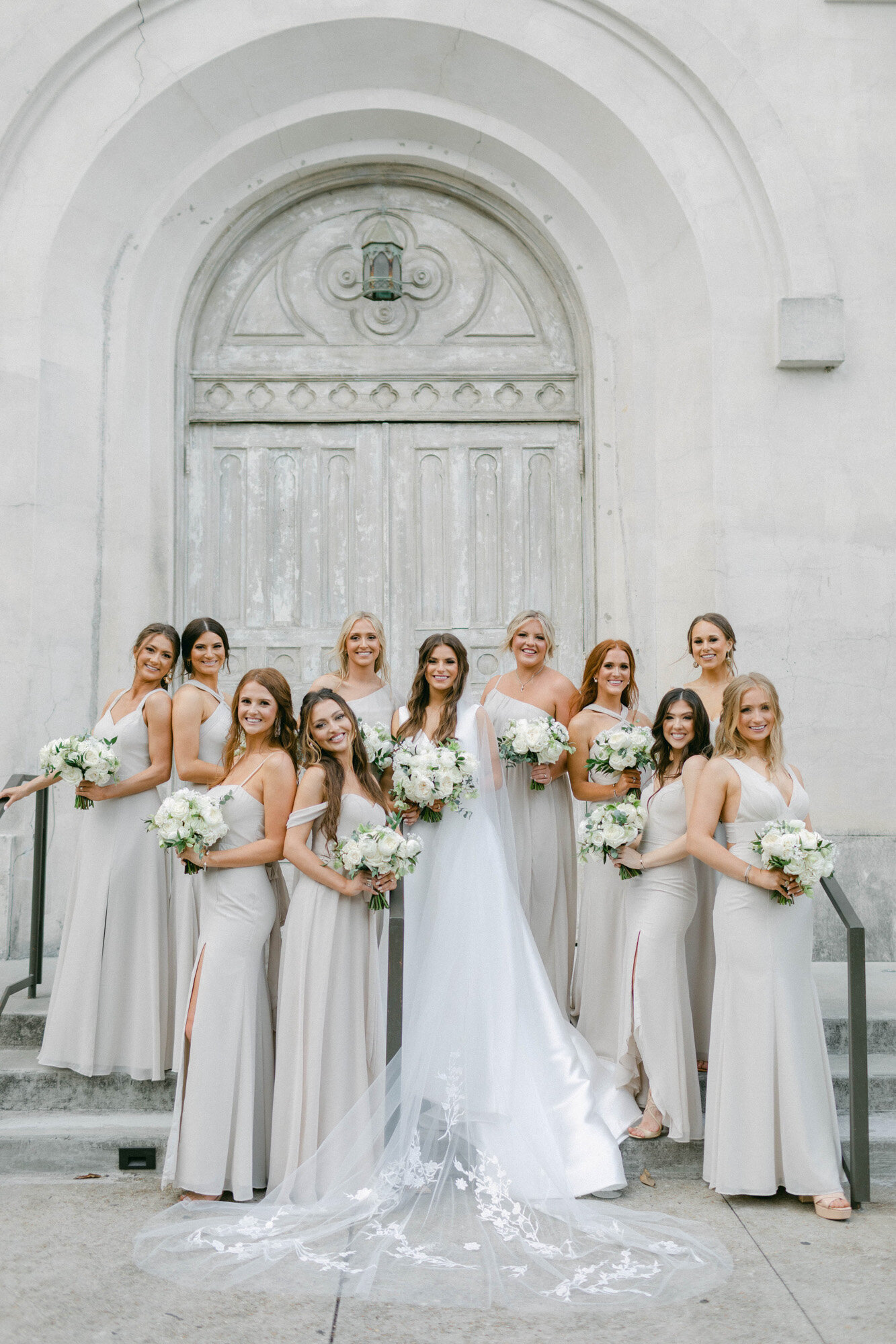 bride and bridal party standing in front of doors