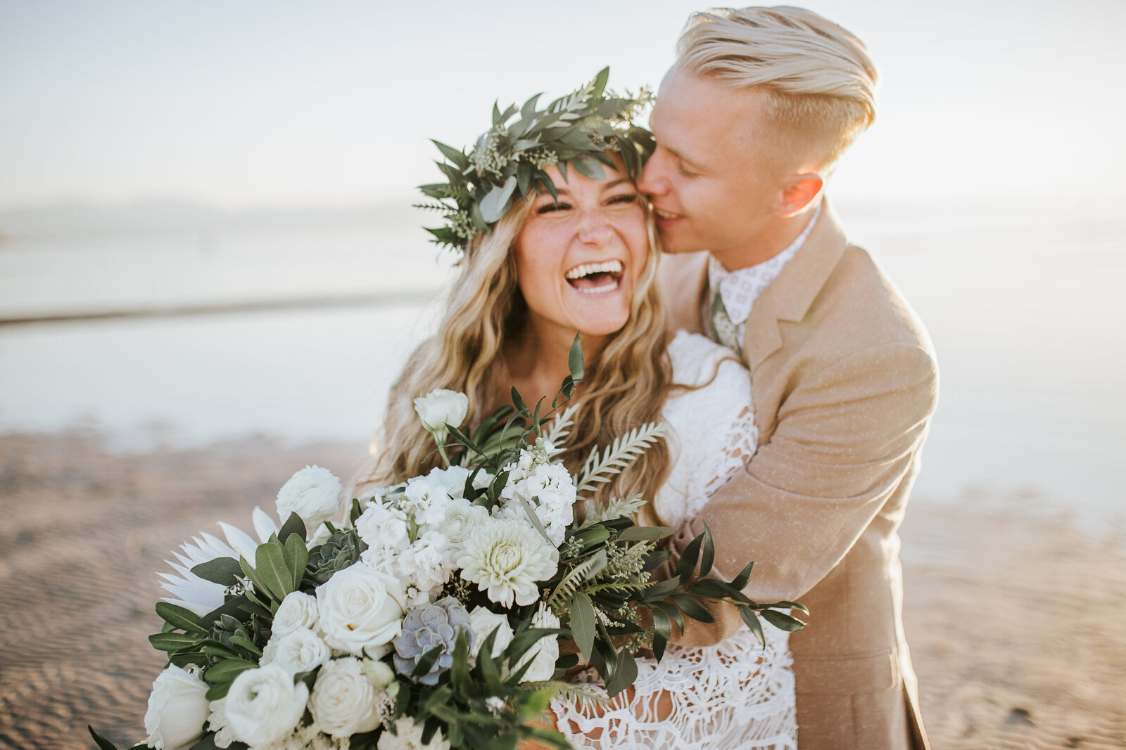 Sacramento Wedding Photographer captures beach wedding with bride wearing floral crown and couple laughing
