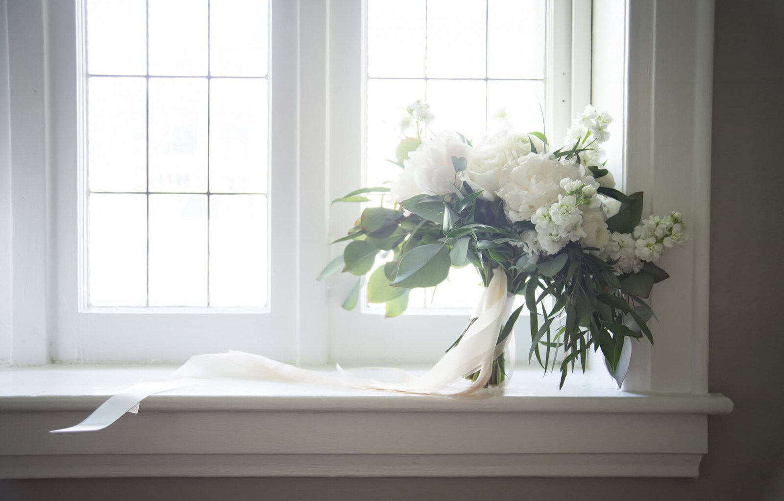 muted bouquet sits in picturesque window