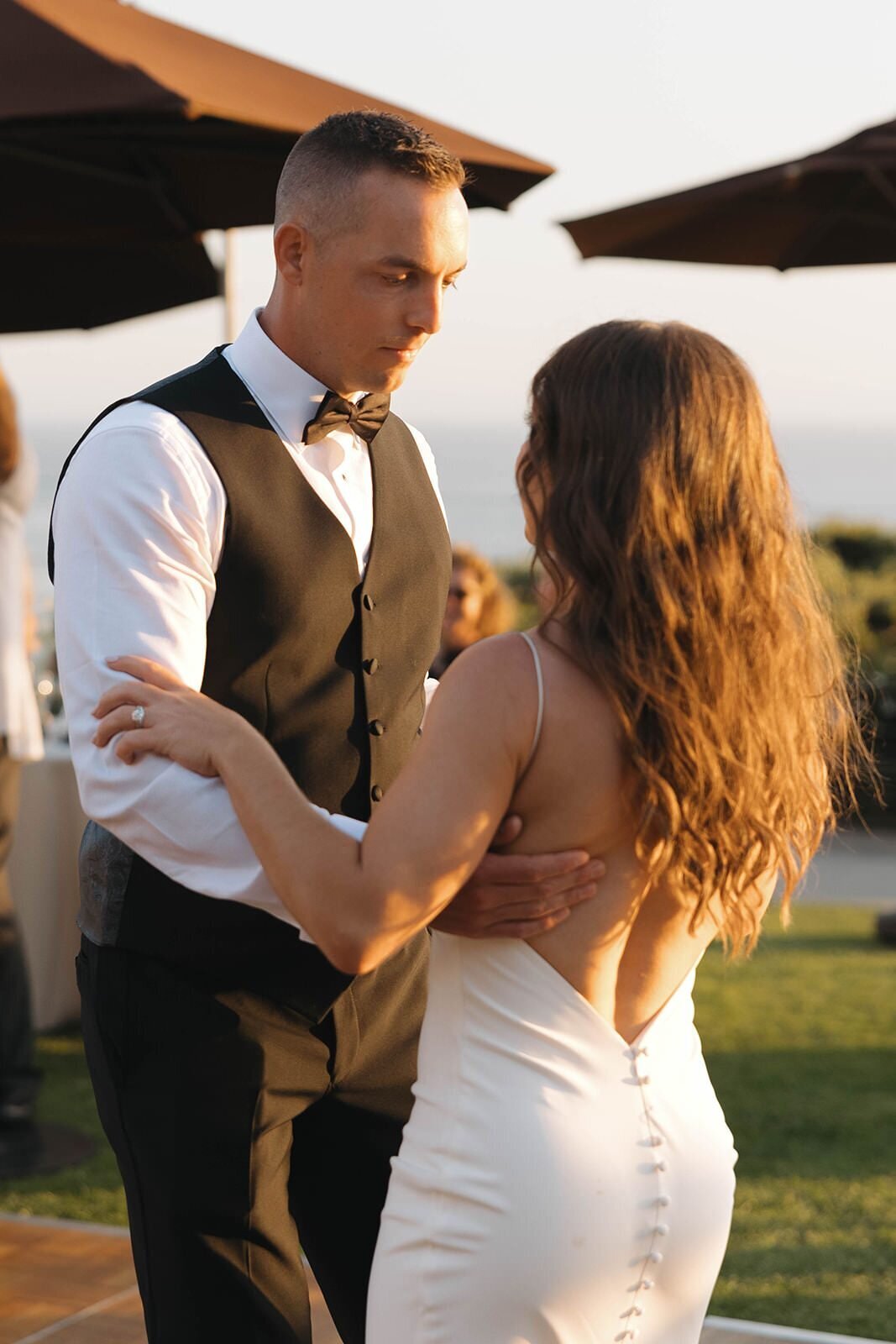 Bride and groom dancing under the patio umbrellas