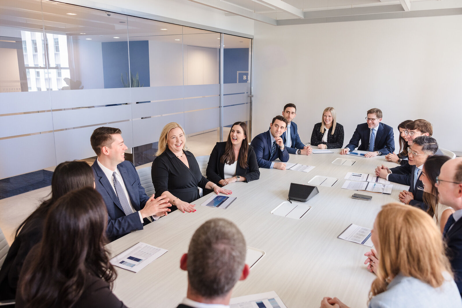 Corporate team meeting photographed in a modern NYC office, showcasing executives collaborating around a conference table.