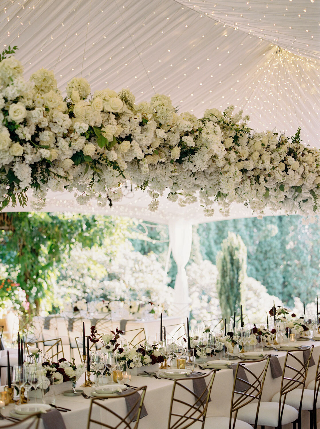 Hanging floral centerpiece over a beautifully set dining table