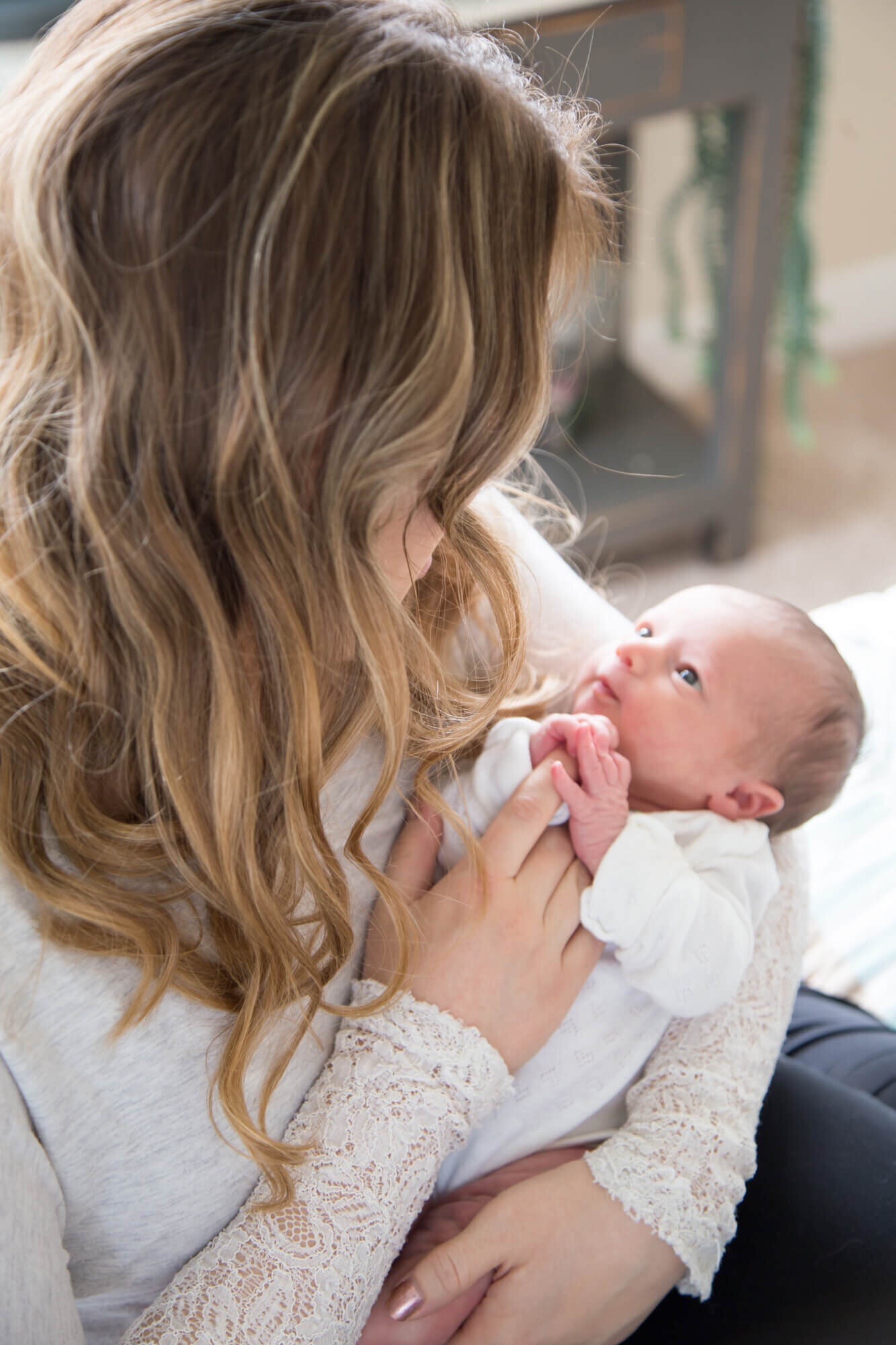 light and airy lifestyle photography of mother looking at her newborn baby girl