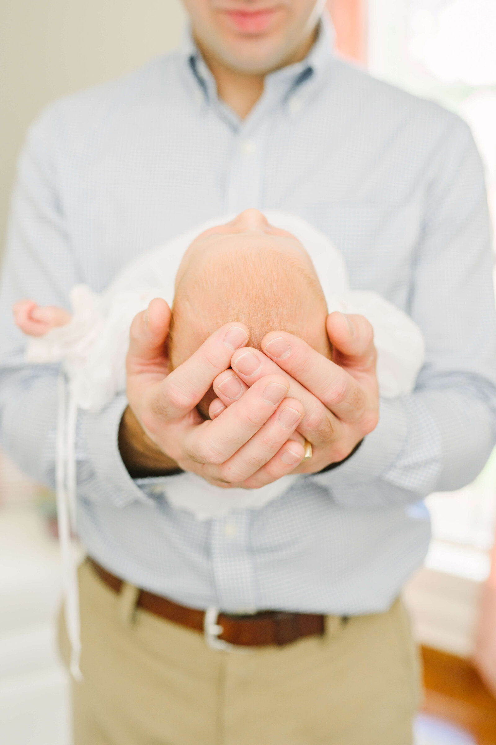 Detail on dad's hand holding babies head