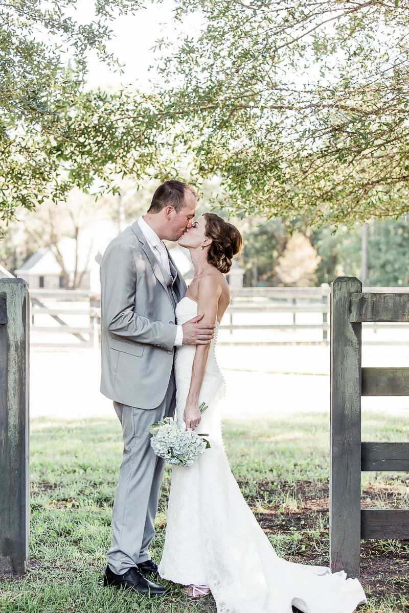 Bride and groom lean on fence, Pepper Plantation, Awendaw, South Carolina