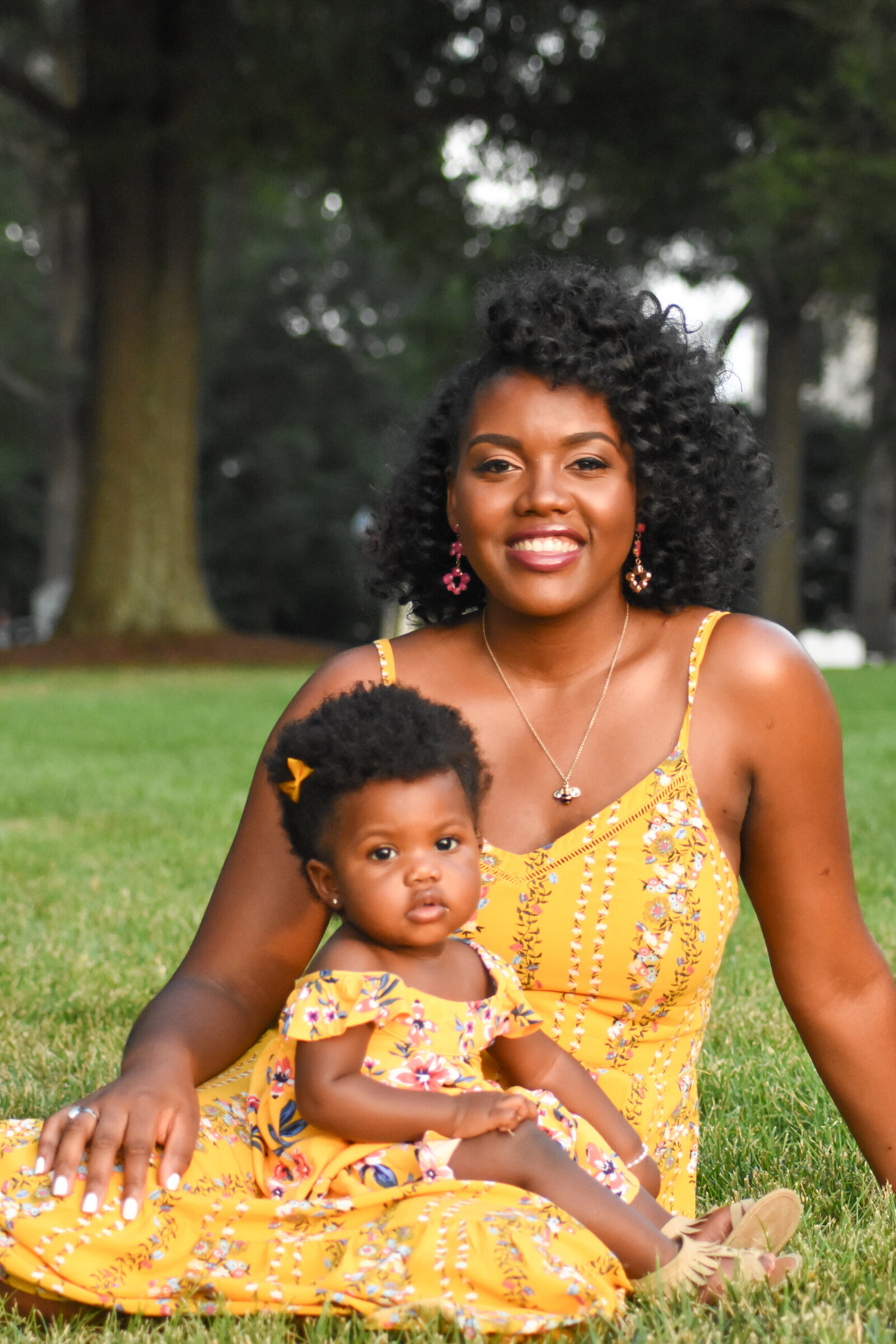 a mother and her daughter in matching yellow dresses posing for a photo in the gross photographed by Millz Photography in Greenville, SC