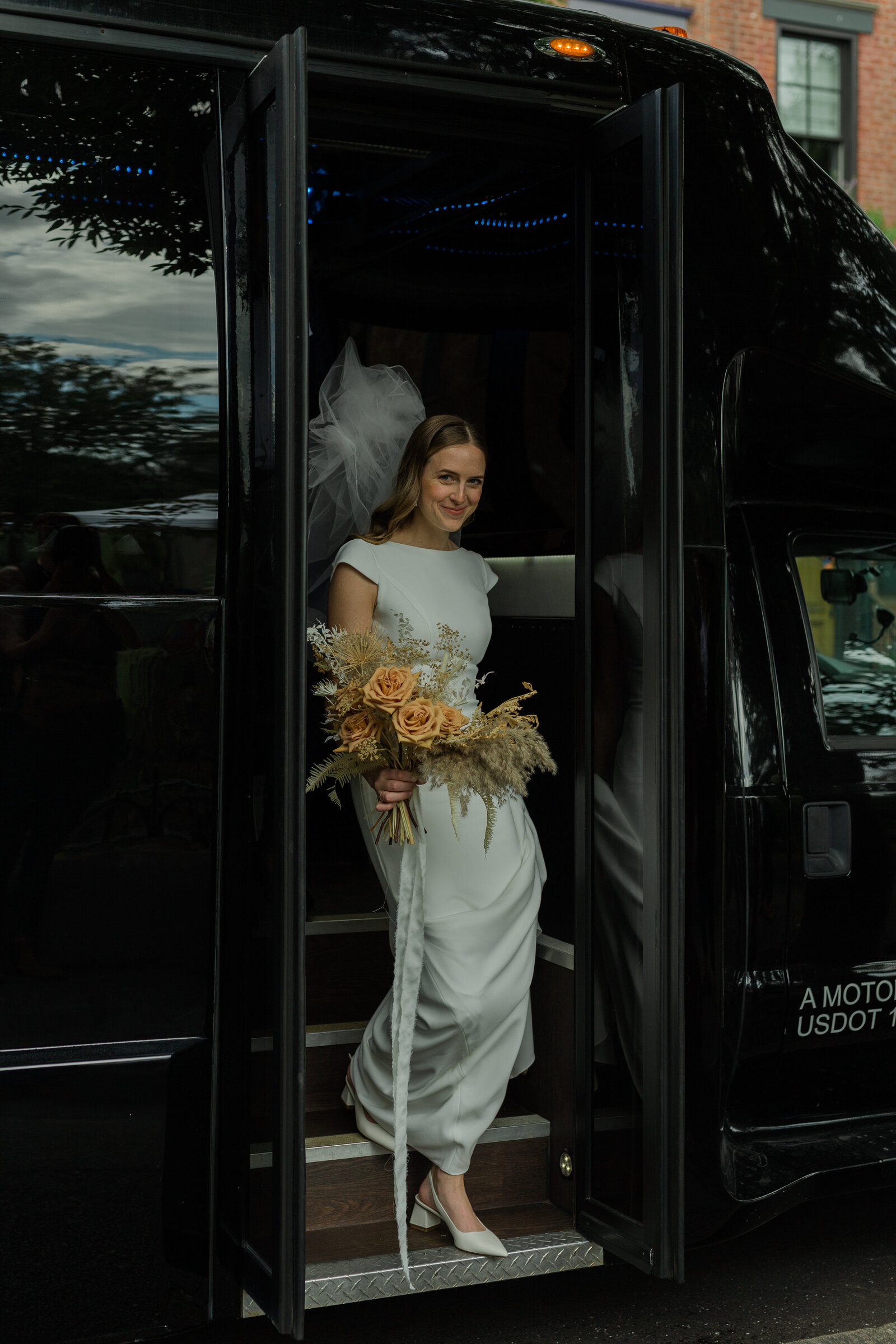 Bride gets out of the bus and looks happy