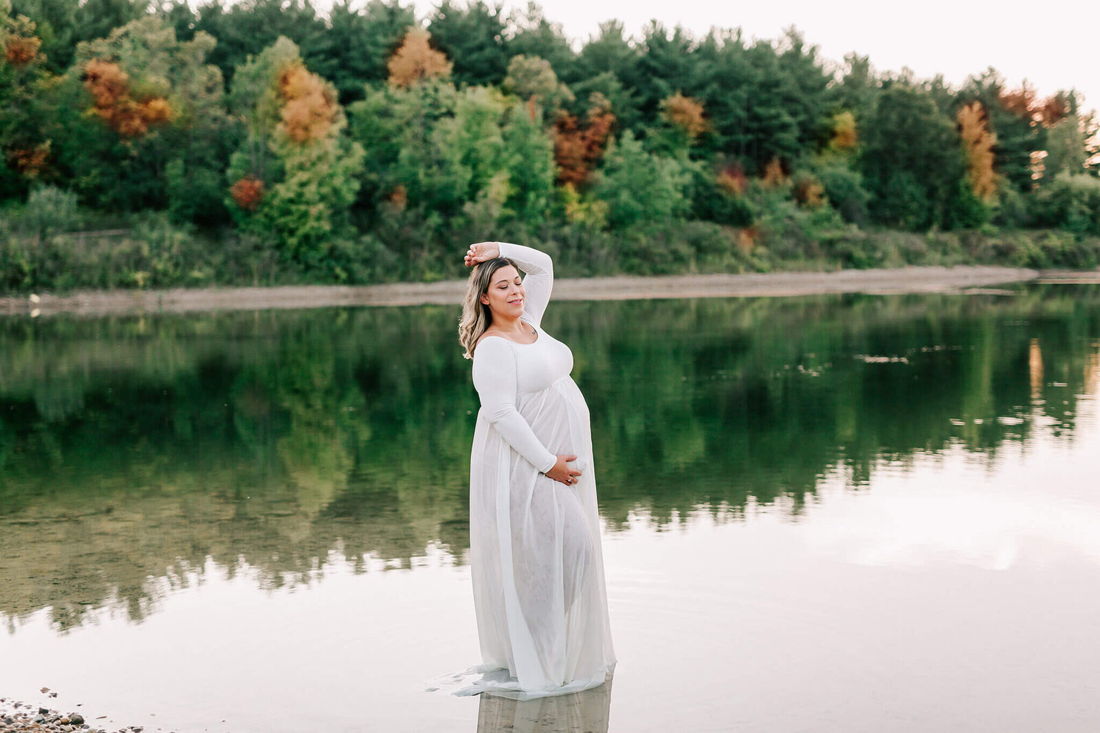 Pregnant mother is photographed by Chelsey Kae Photography while standing in the Puslinch Twin Ponds.