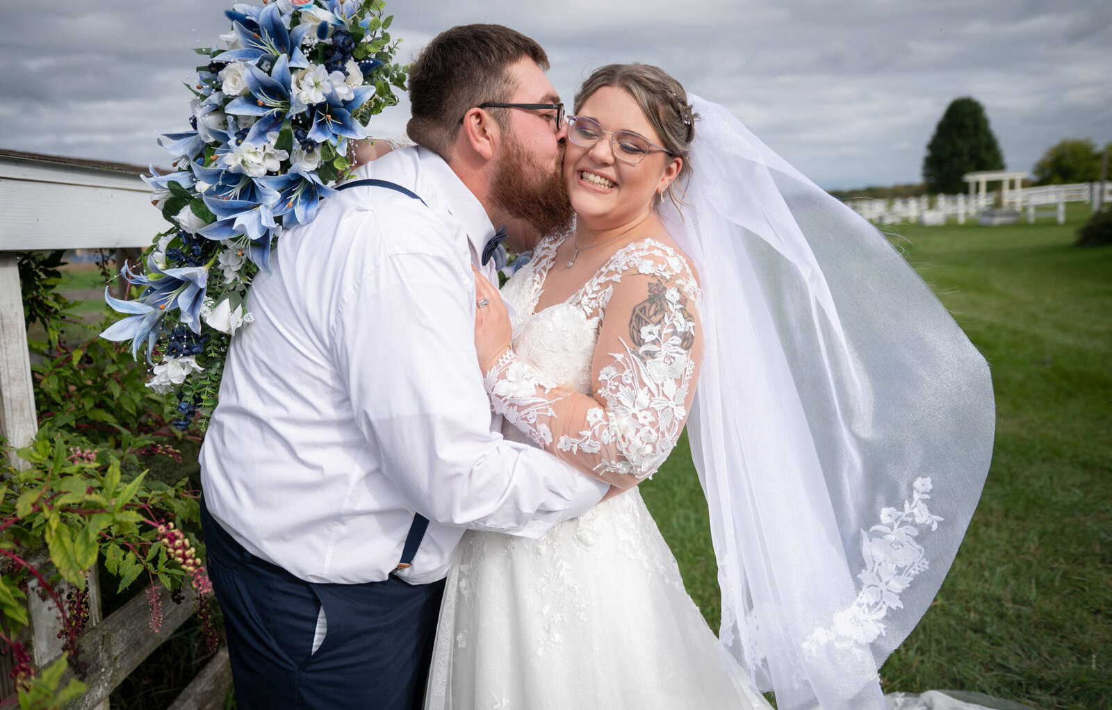 bride laugh's as groom kisses her cheek