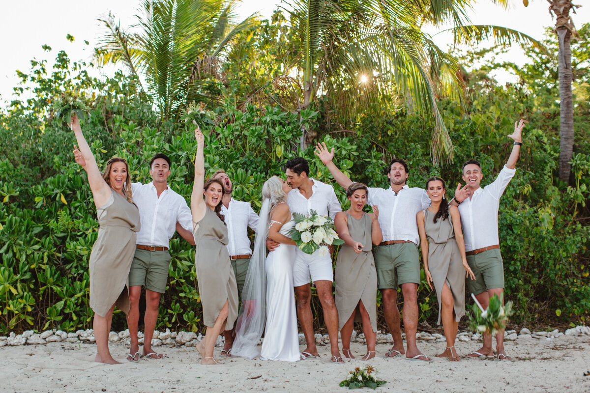 bridal party cheering and couple kiss