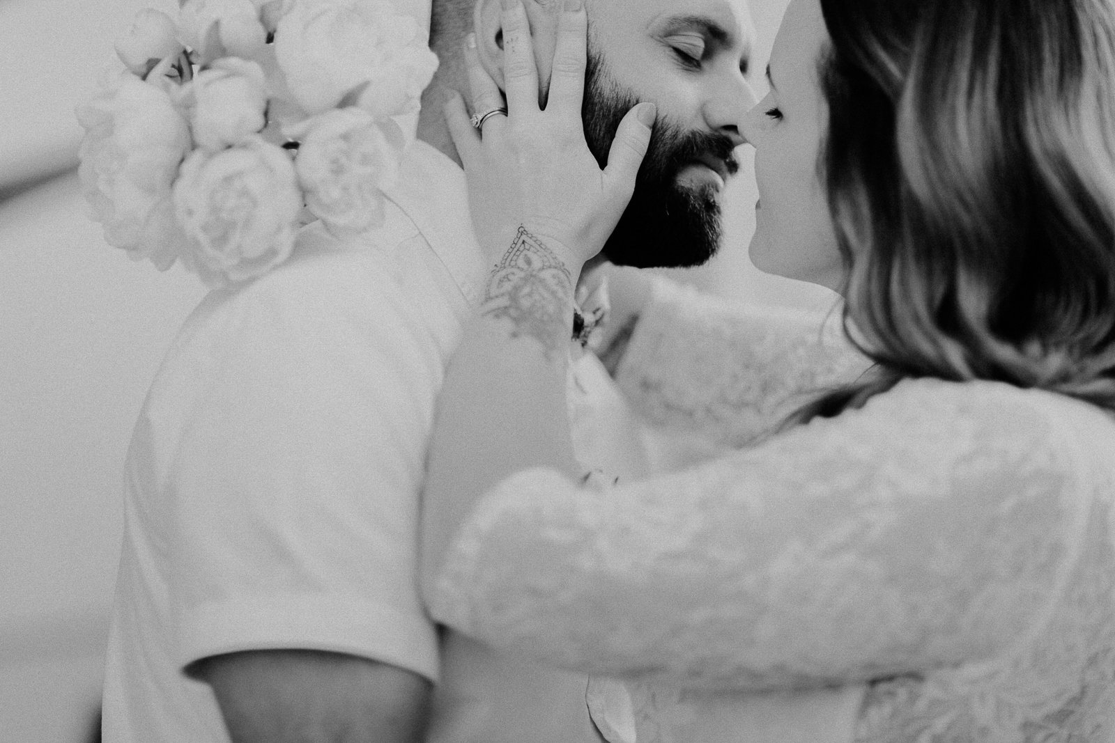 bride pulls groom in for intimate kiss in black and white photo