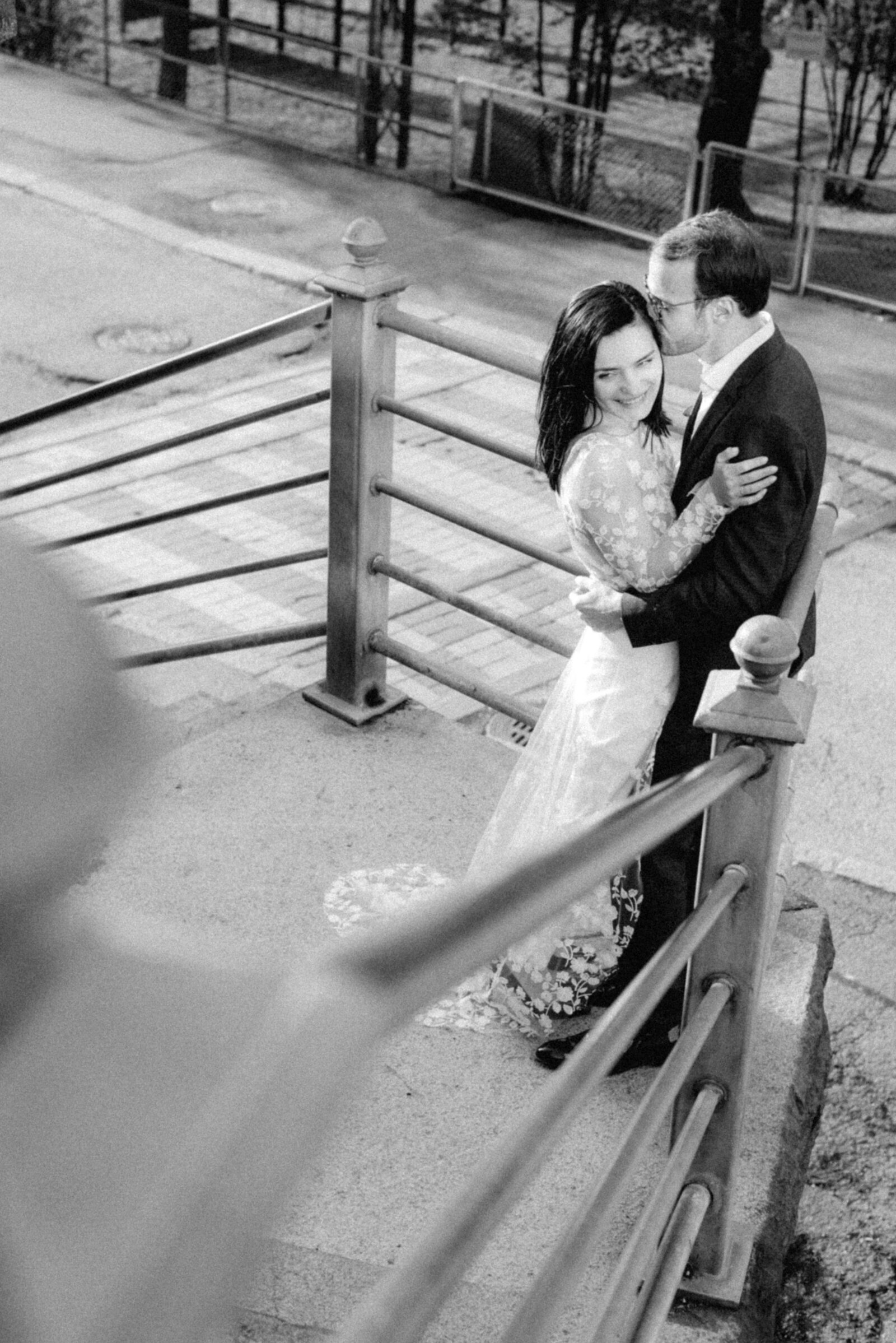 Black and white elopement photograph of a wedding couple hugging on the stairs in Helsinki. The wedding photographer Hannika Gabrielsson photographed the couple in Finland.