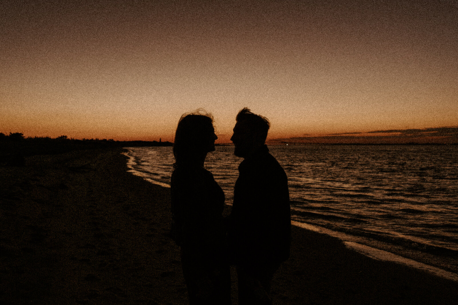 couple embracing on the beach at sunset