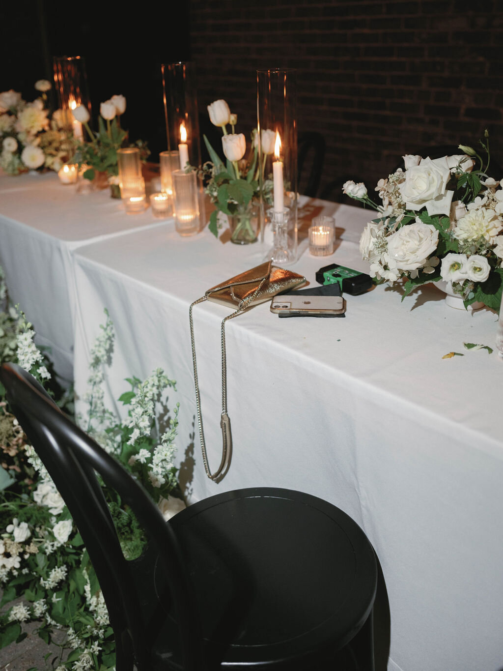 Head table with compote arrangements and pillar candles down the length of the table.
