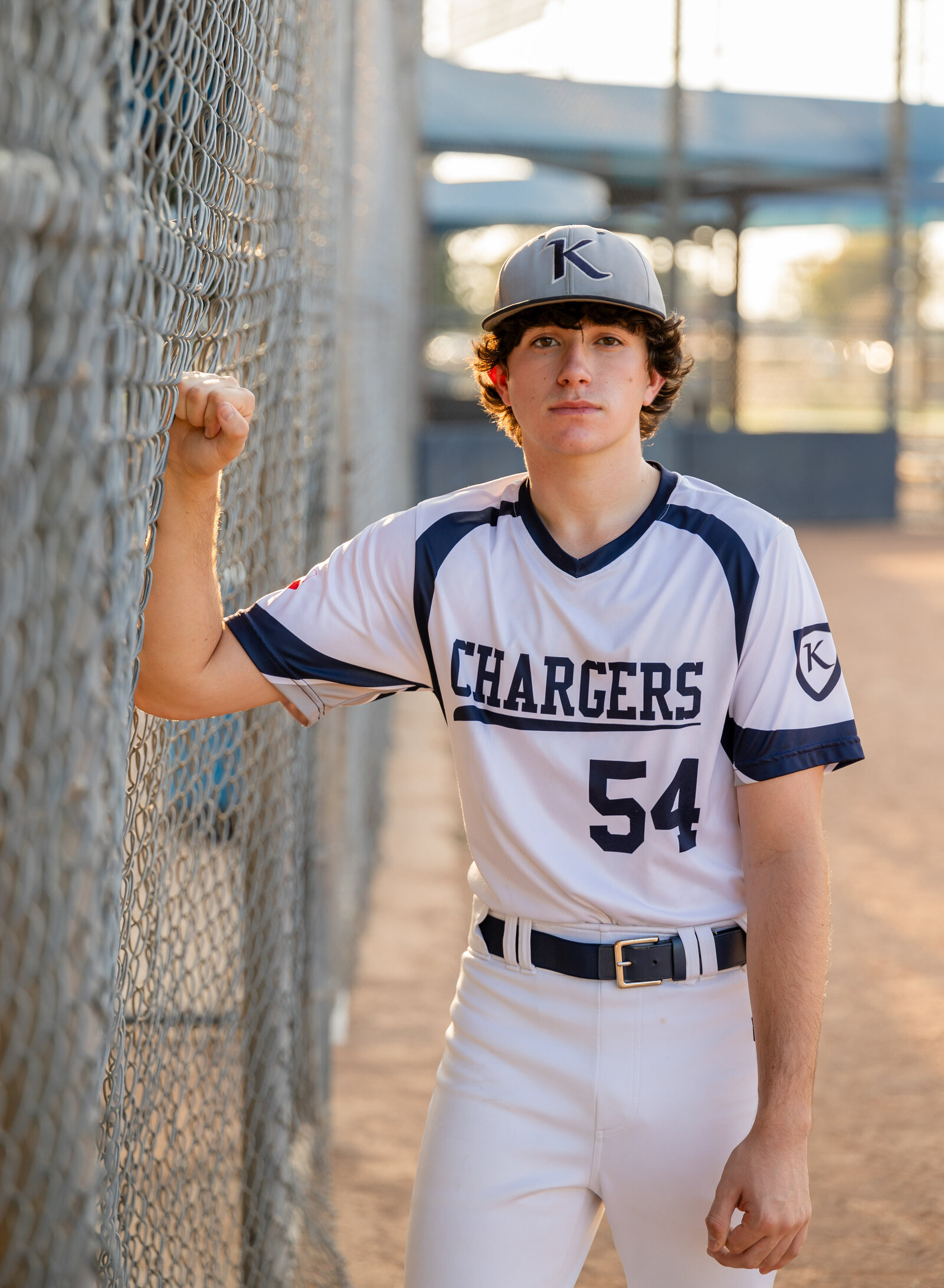 boy by baseball fence