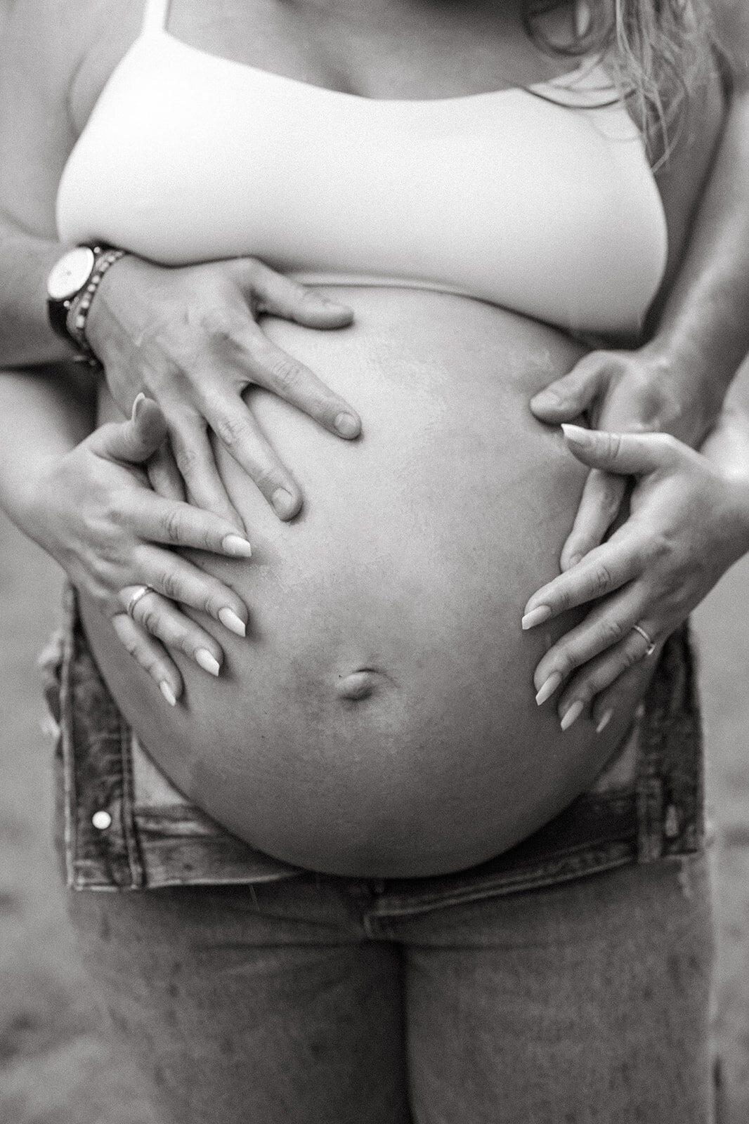 black and white photo of hands on a belly