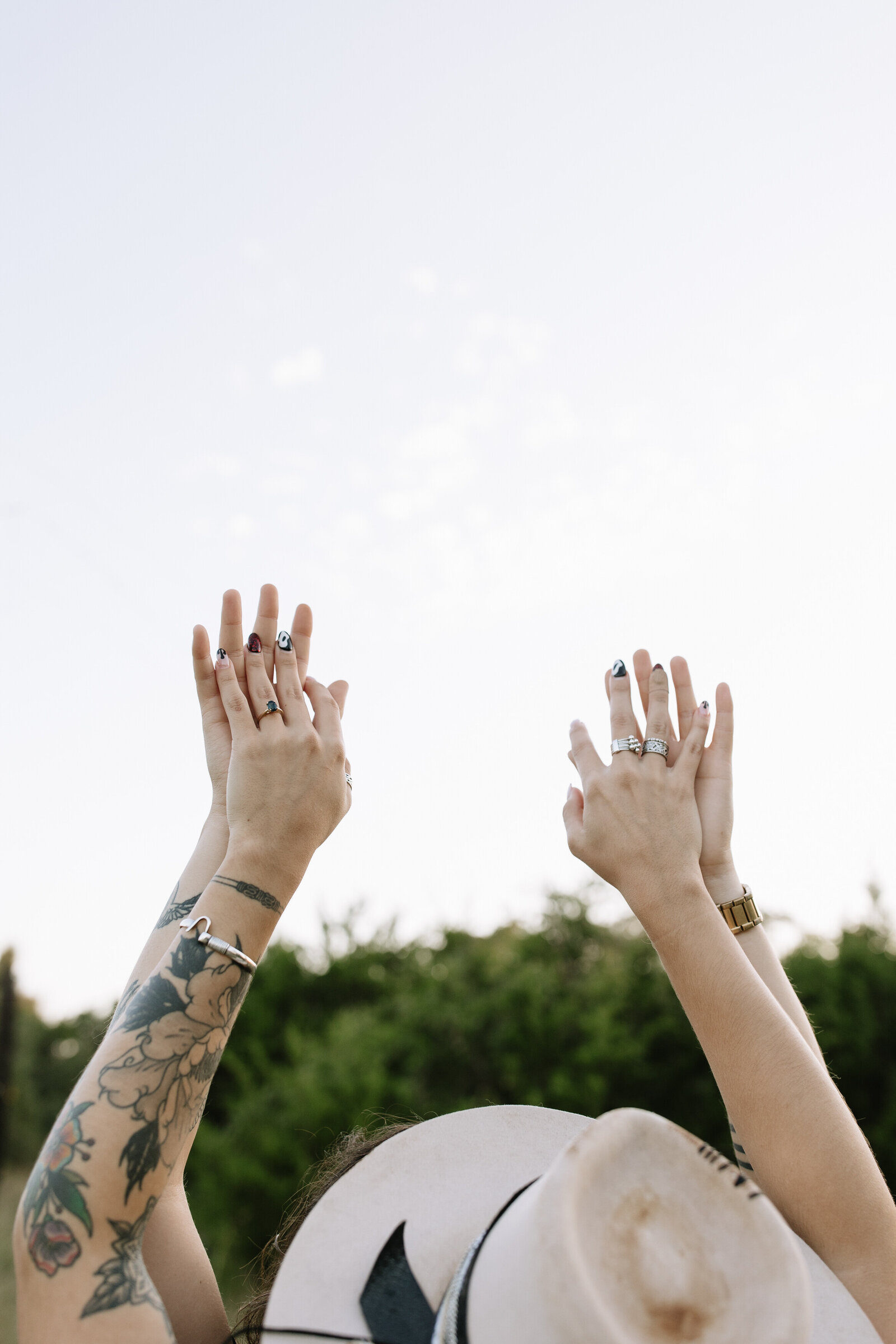 LGBTQ+ couple showing off rings in celebration of their engagement in Austin