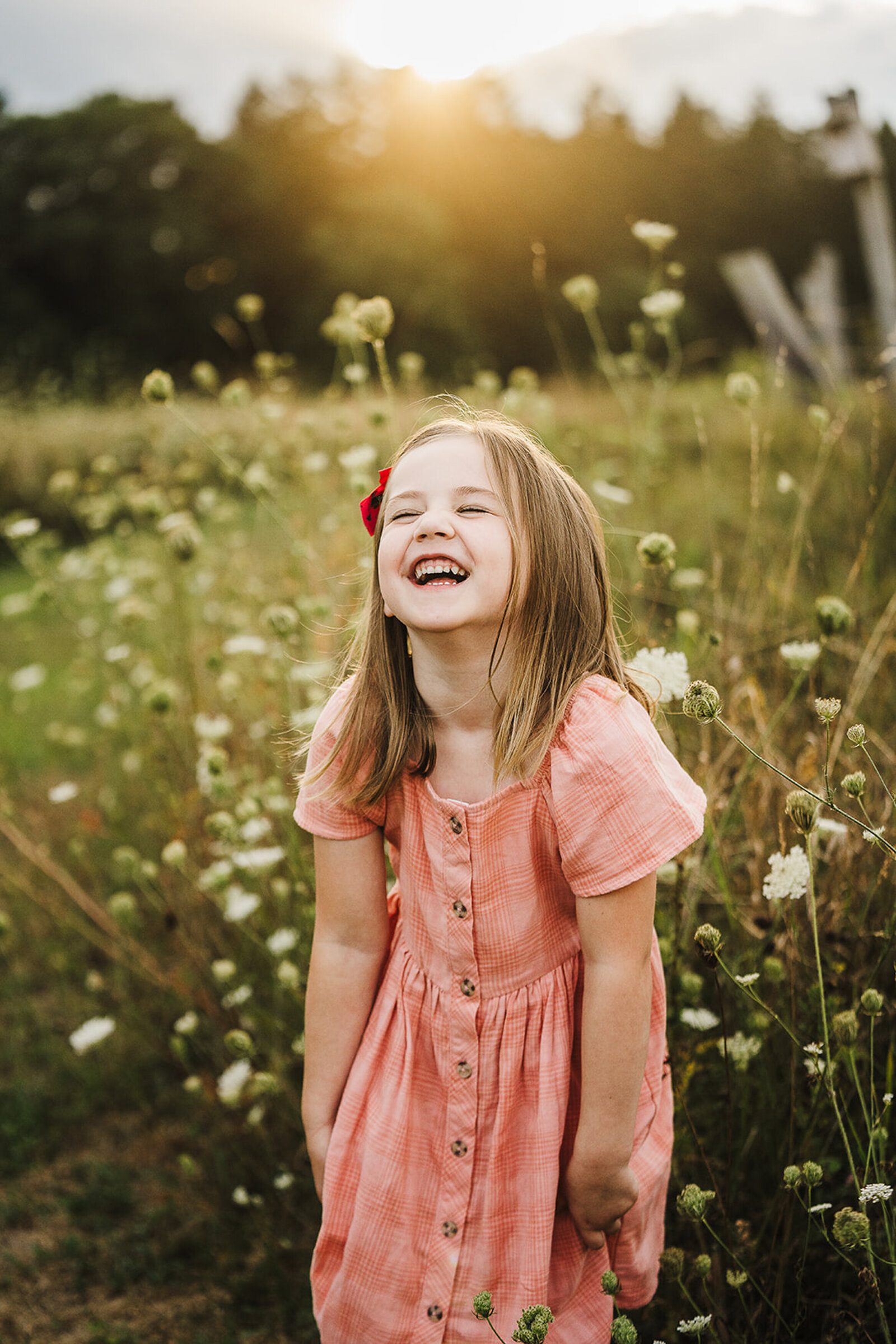 little girl laughs in pink dress