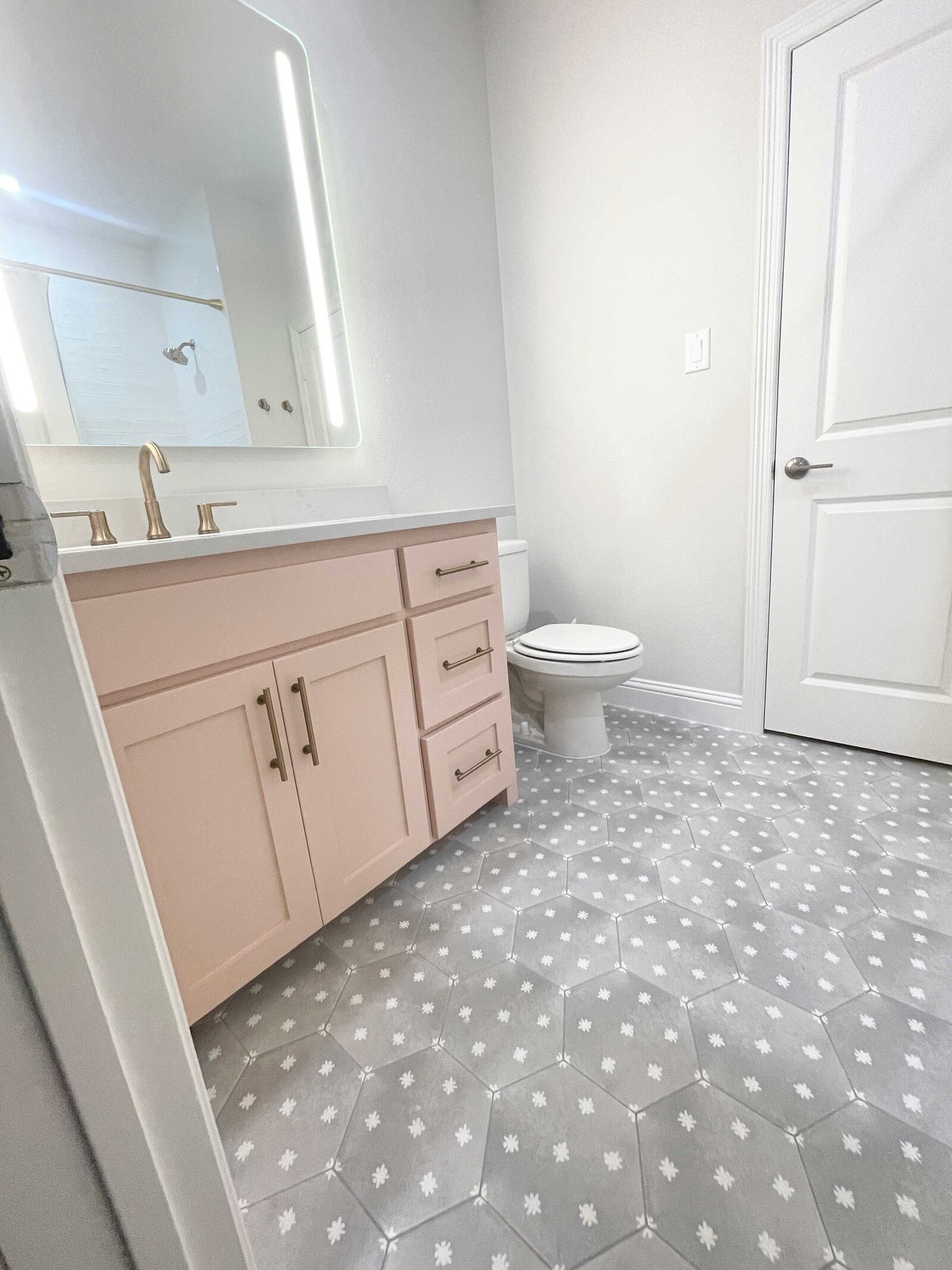 Full home renovation design for a white and pastel pink bathroom, featuring elegant materials, stylish fixtures, and a serene atmosphere, blending modern aesthetics with soft, calming colors.