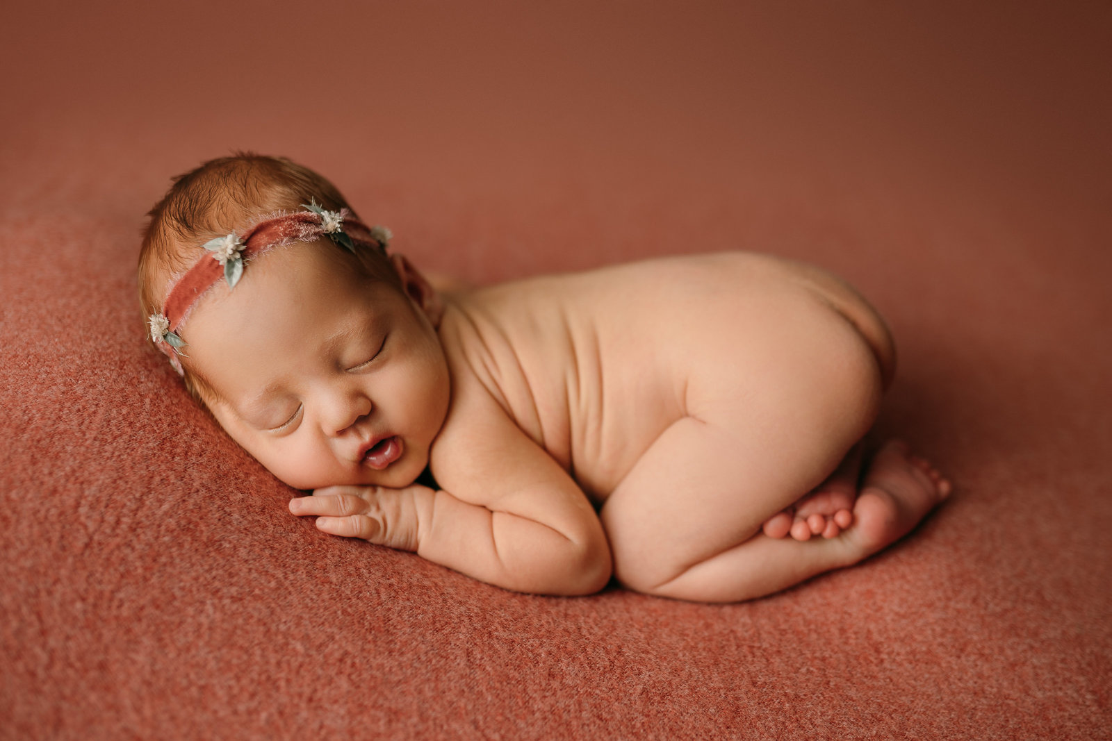 newborn girl poses on pink during photography session in Clearwater