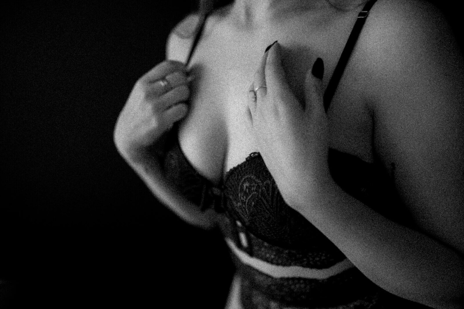 womans chest with hands on chest wearing green lace lingerie