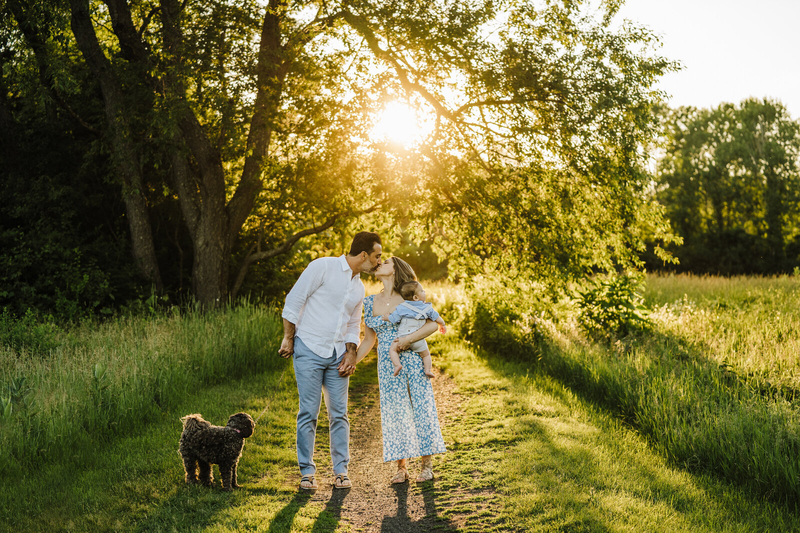 family walks into sunset with boy and dog