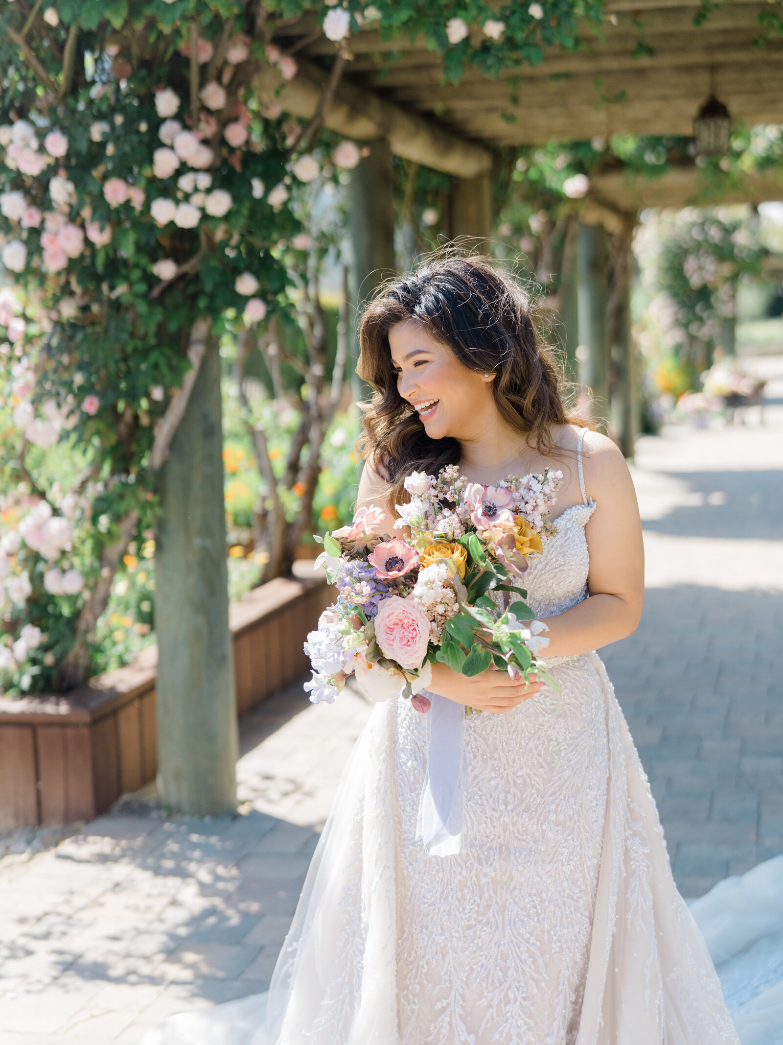 bride smiling and holder her bouquet in a garden