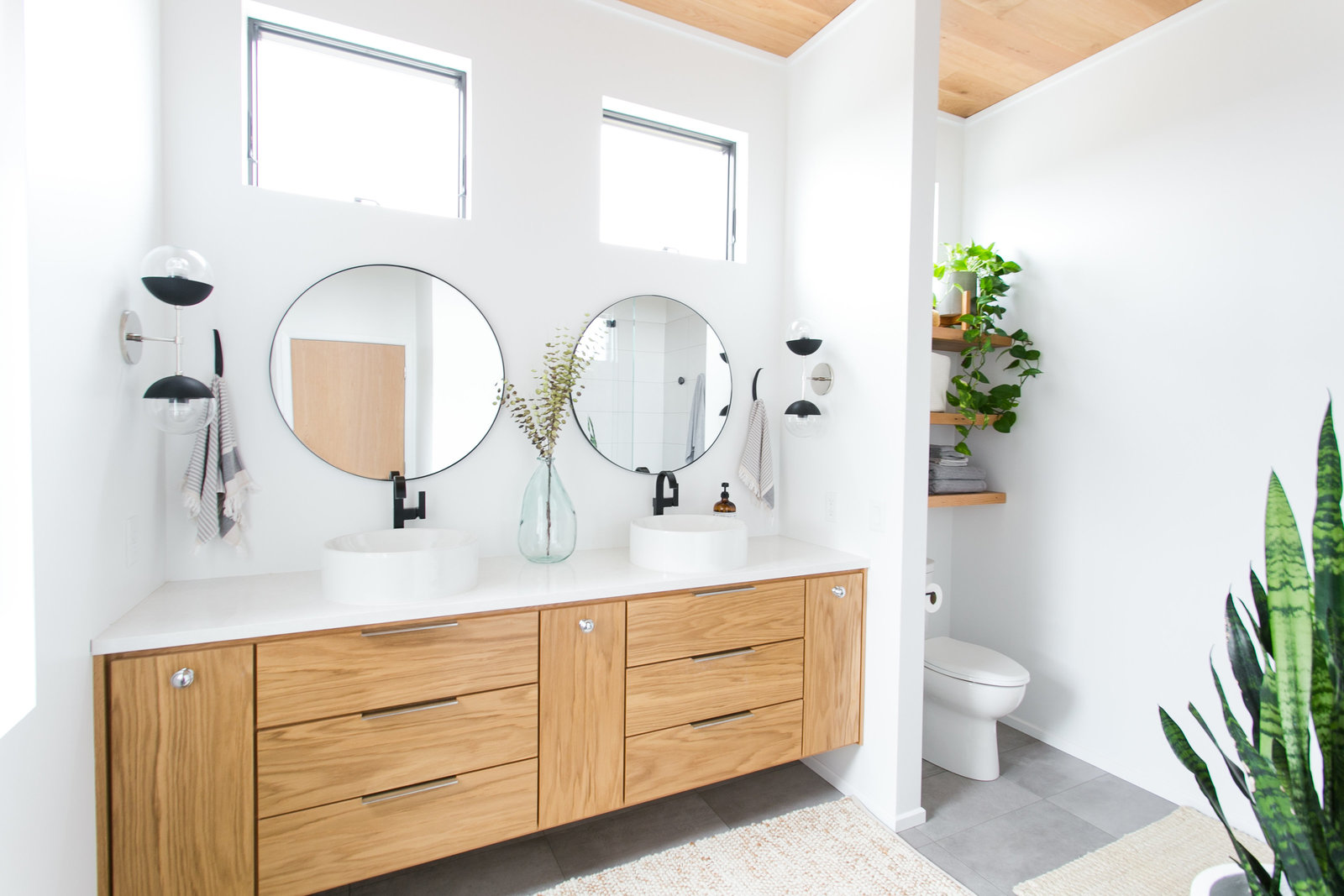 Modern master bathroom design with vessel sinks, floating shelves and vanity