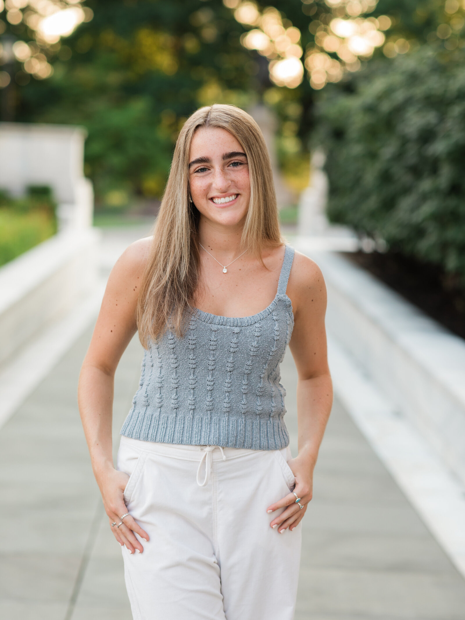 senior girl in gray shirt posed at art museum for senior portraits cleveland senior photographer
