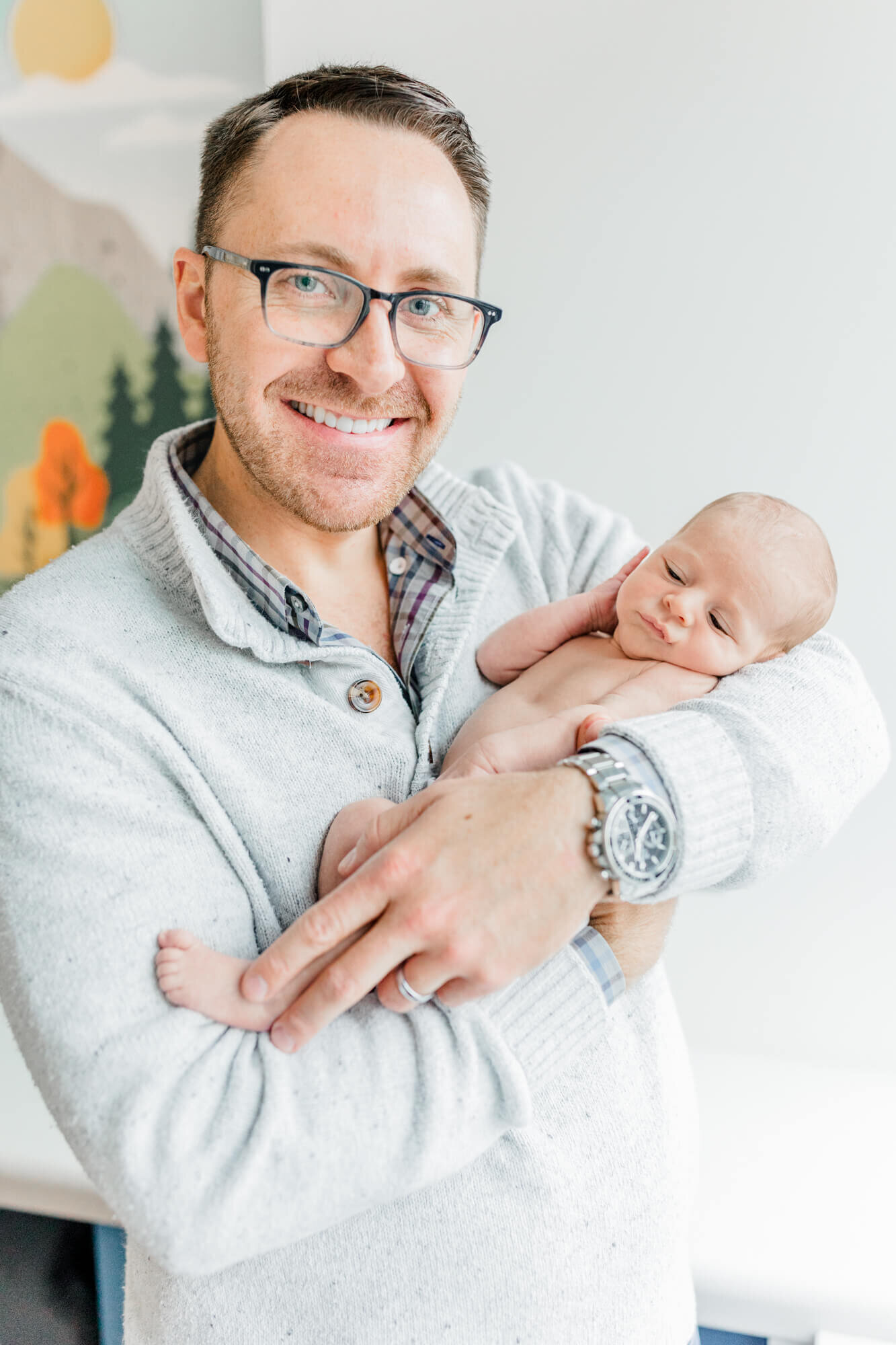 Dad smiling while holding his newborn