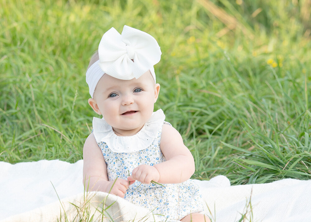 little-girl-sitting-in-grass-with-big-bow