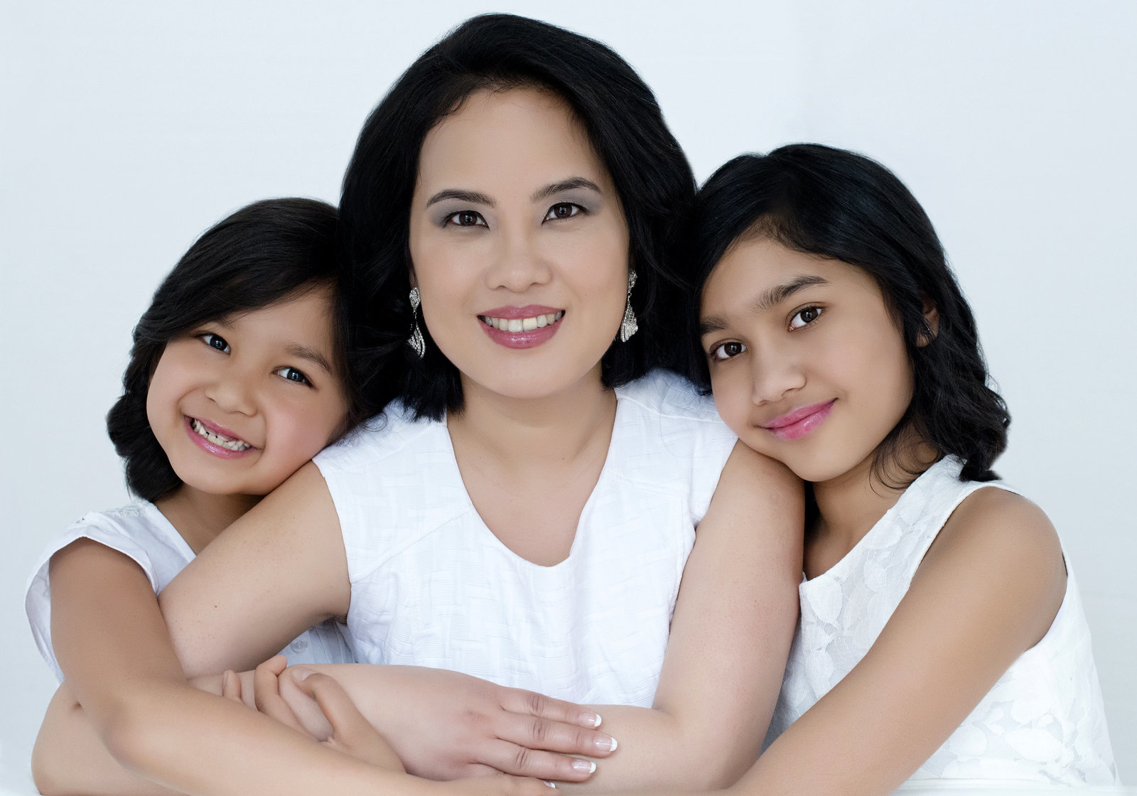 Portrait  of mother with her 2 loving cute daughters  hugging and  looking into camera. best  family portrait