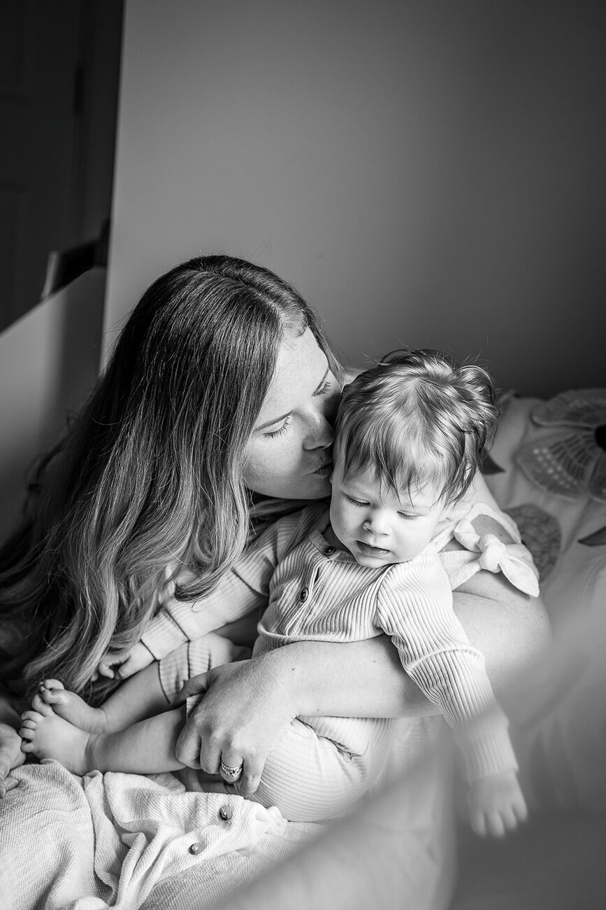 black and white portrait of mother snuggling toddler daughter