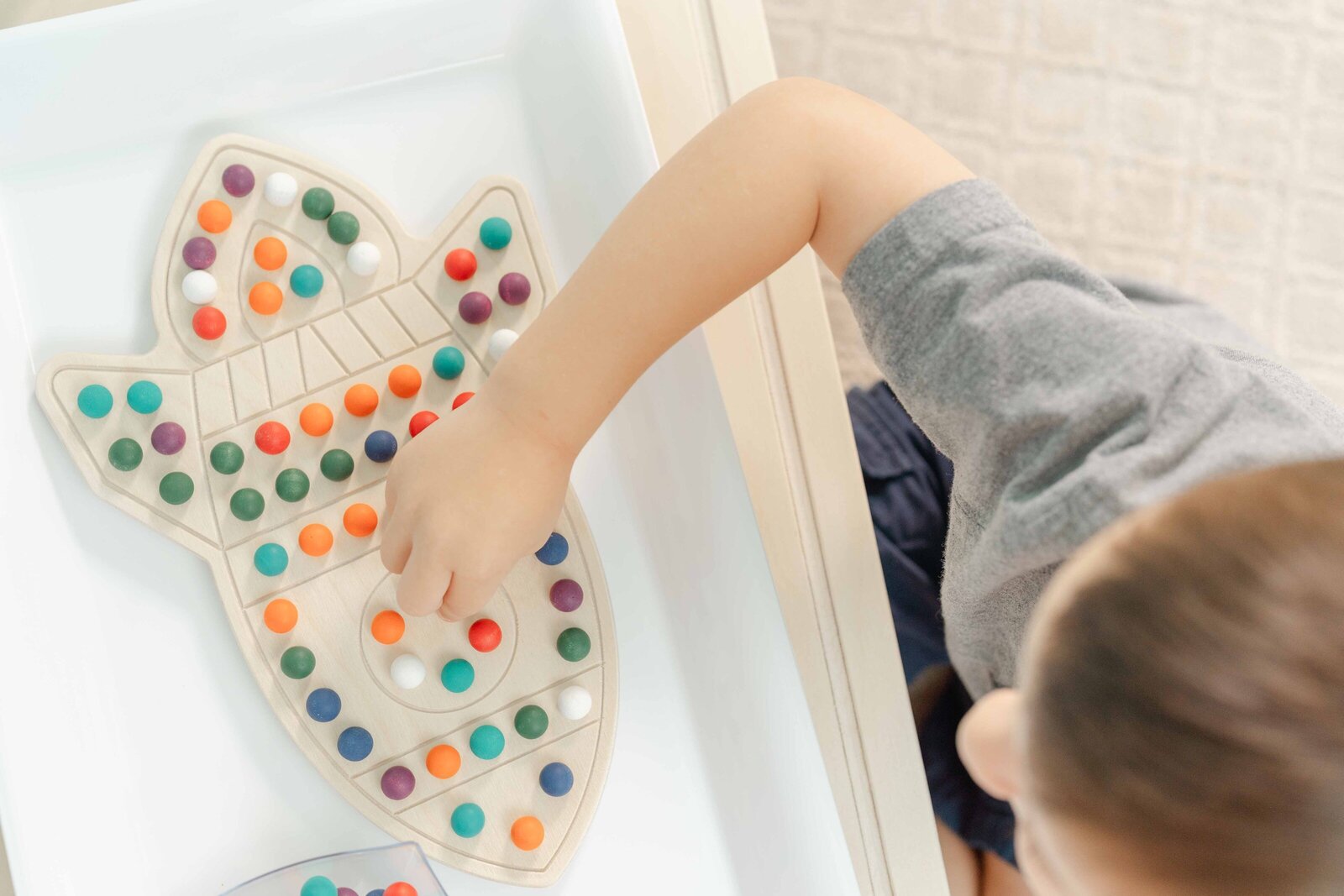 boy playing with rocketship activity board during product photography in Vienna,VA