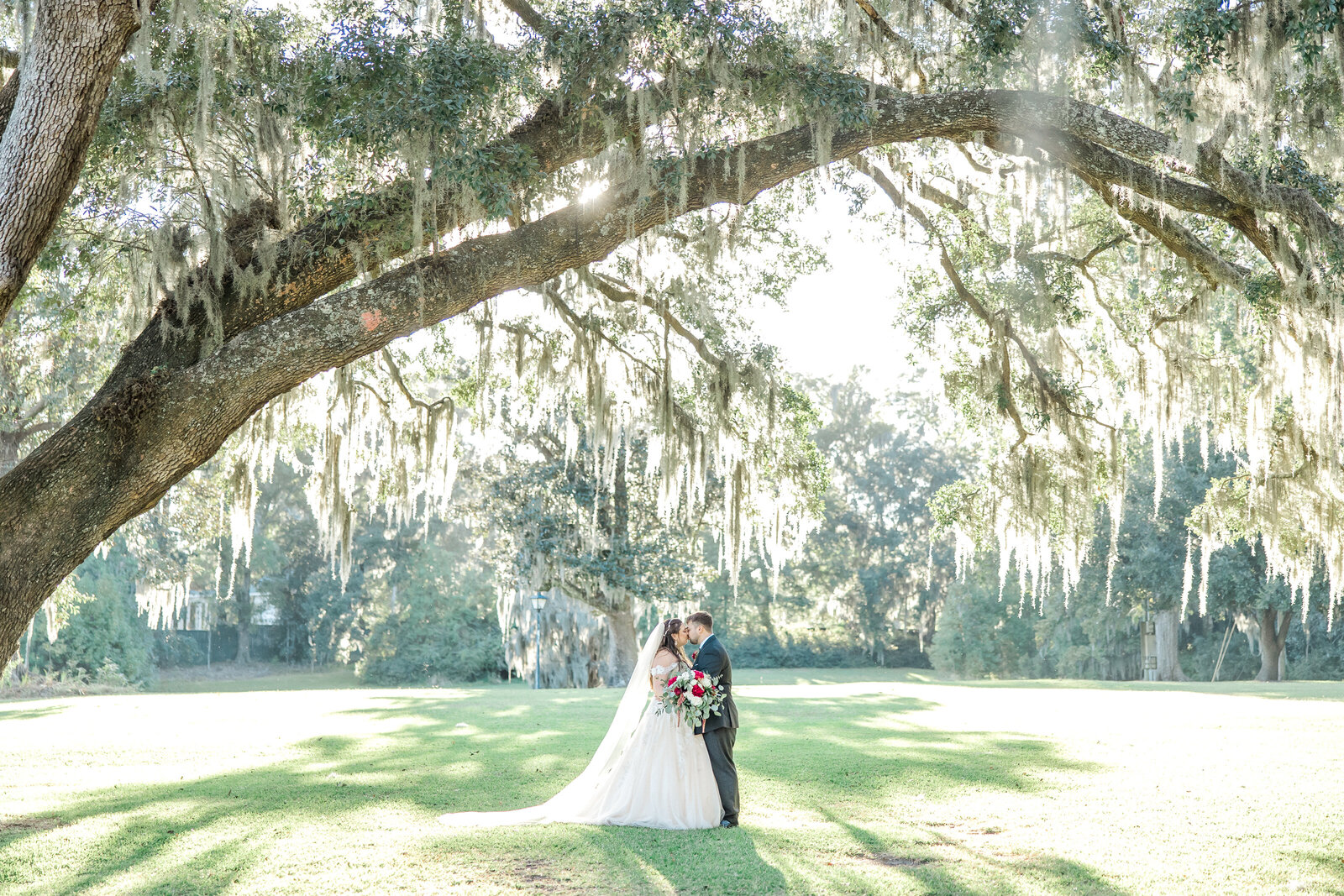 Engaged couple embrace in outdoor Bluffton setting by Karen Schanley.