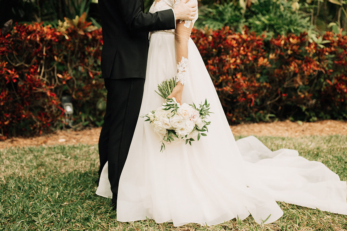 bride and groom standing together with bouquet
