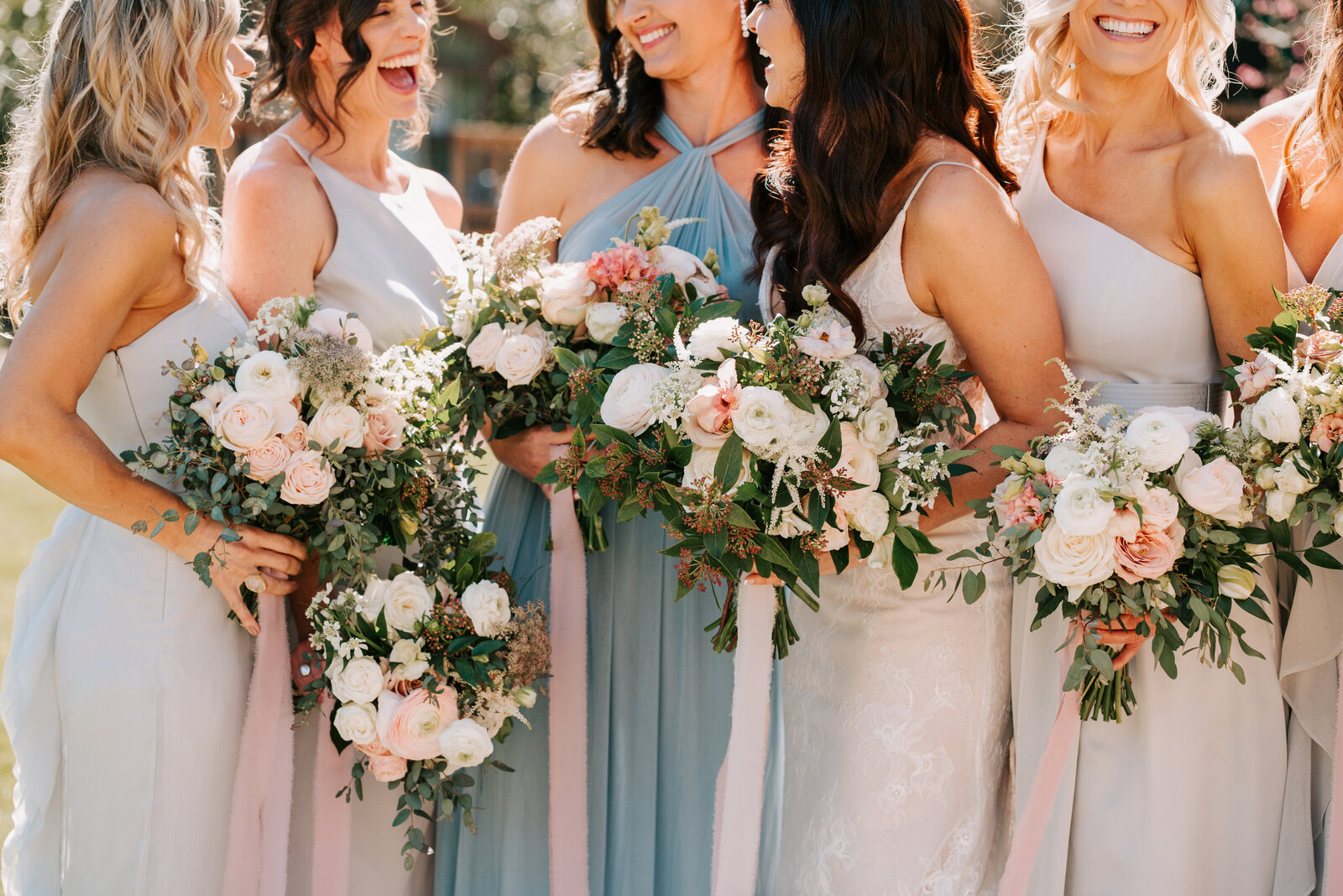 bridesmaids laughing holding bouquets