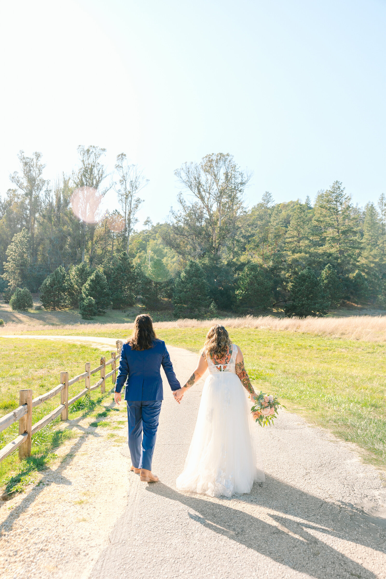 Tattoo bride and groom embrace on their colorful wedding day in Santa Cruz, California.