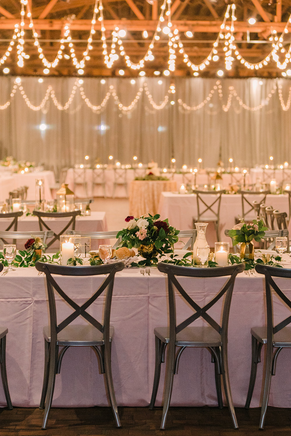 Twinkling lights, candles and lush florals decorate this romantic wedding reception at Rockwell on the River.